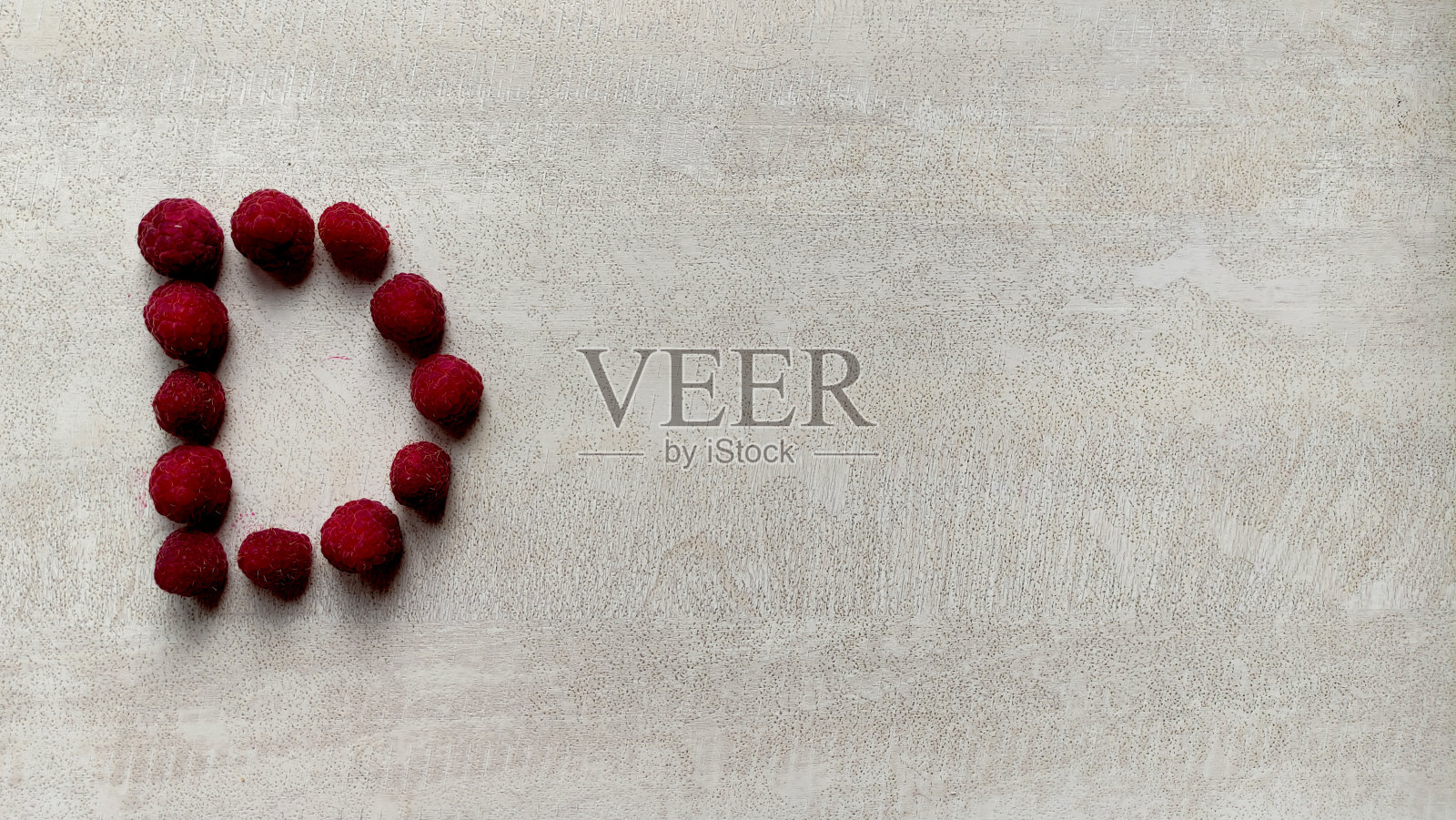 树莓字母D顶视图在一个白色纹理的桌子，大的树莓浆果照片摄影图片