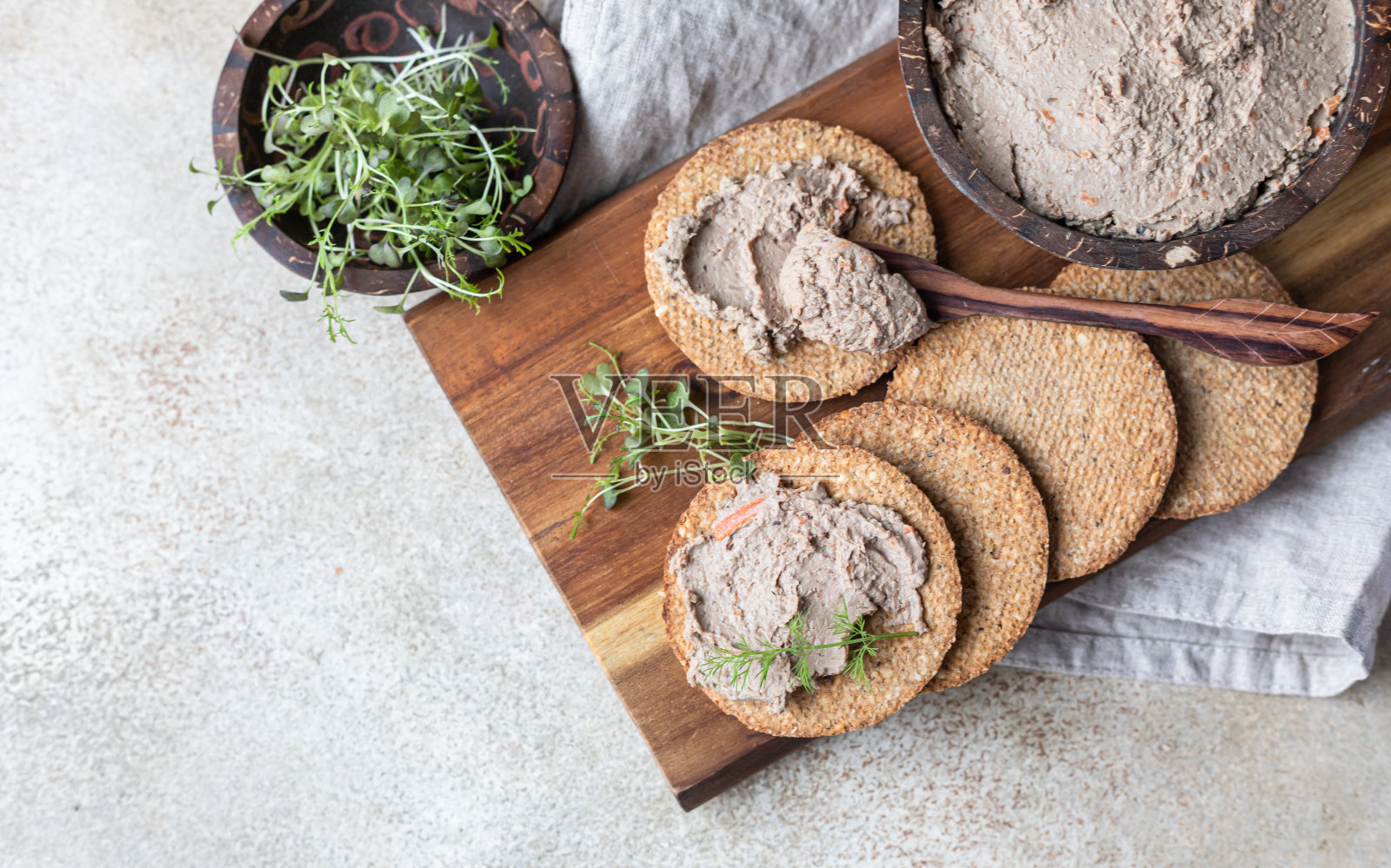 自制肉或鸡肝酱配杂粮饼干和微绿色混凝土背景。前视图。照片摄影图片