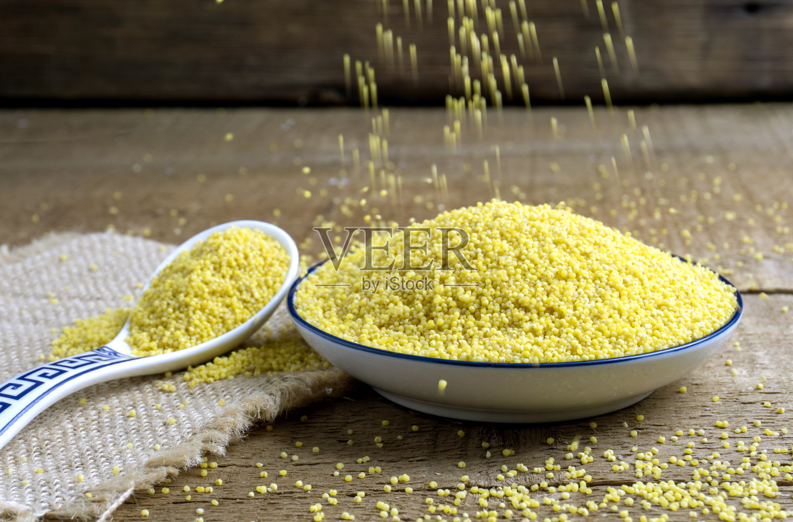 新鲜的小米放在木头上。照片摄影图片