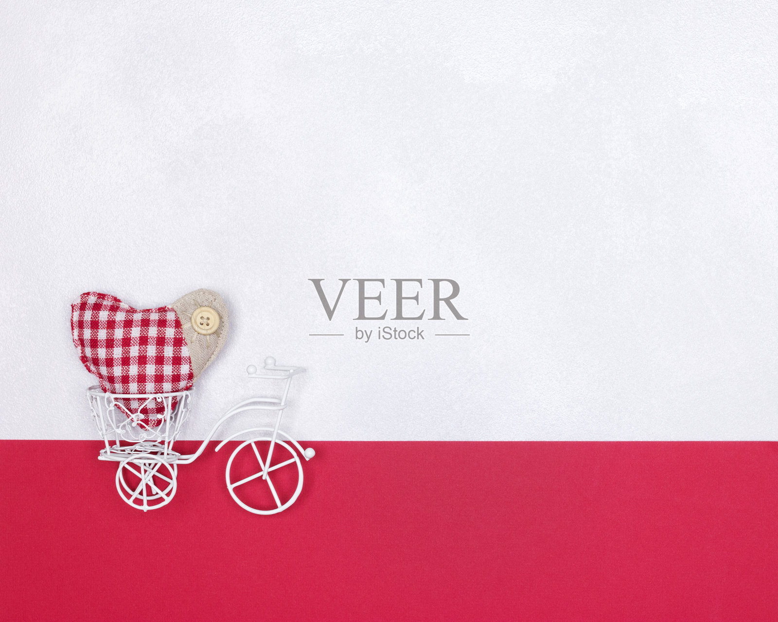 红色纺织心形装饰的白色玩具自行车，浪漫爱情极简概念照片摄影图片