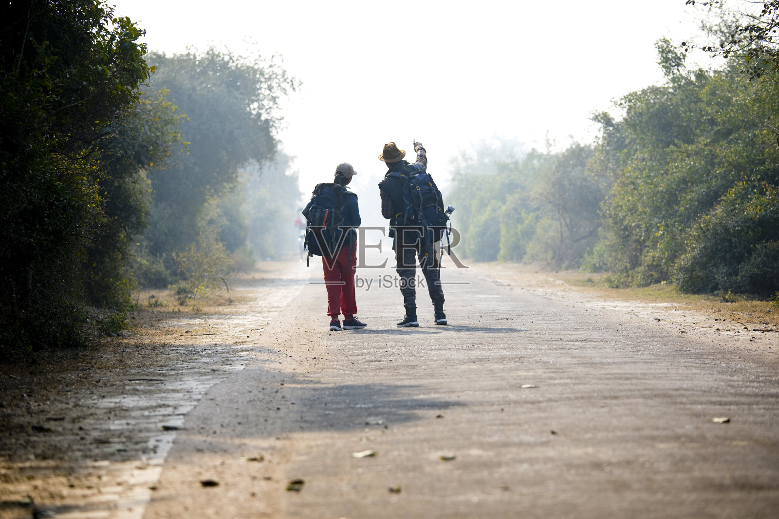 一对年轻夫妇走在通往森林的路上照片摄影图片