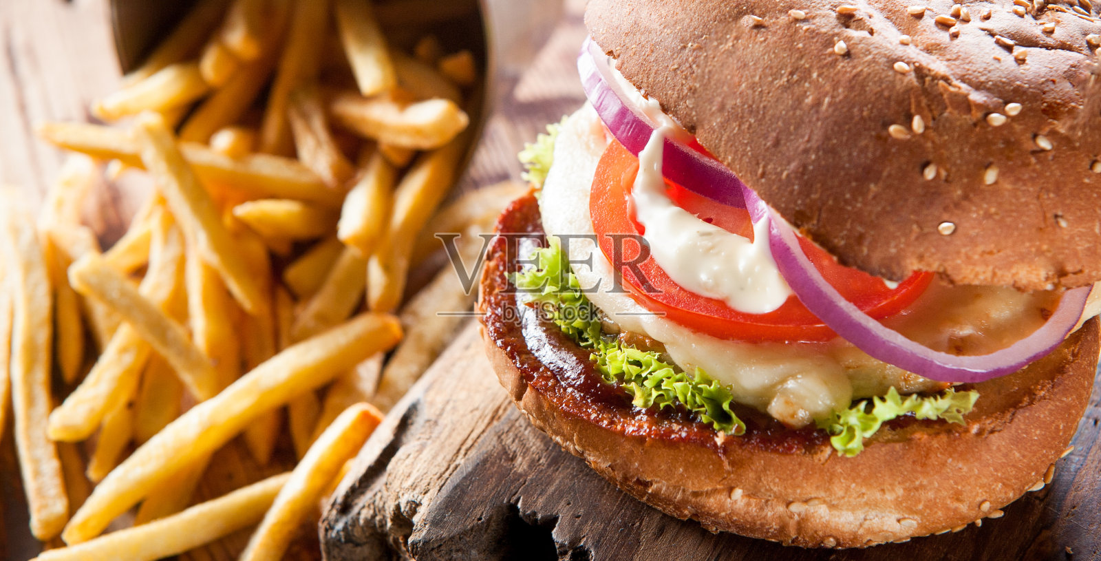 一个肉饼的特写放在一块木板上，旁边是土豆照片摄影图片