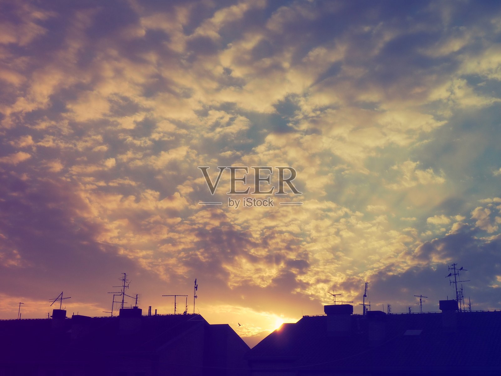 美丽的，粉红色和黄色的夕阳在天空中。云层被低低的阳光染成了颜色。蓝色的天空。美妙的风景。照片摄影图片