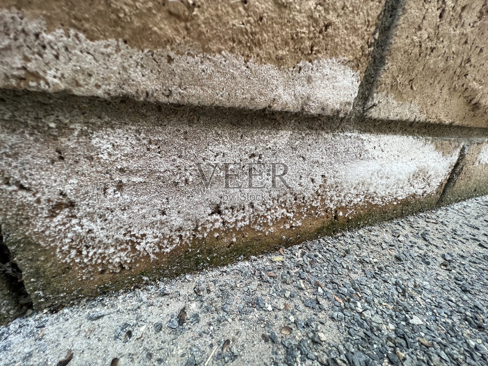 茶色砖墙上有白色残留物照片摄影图片