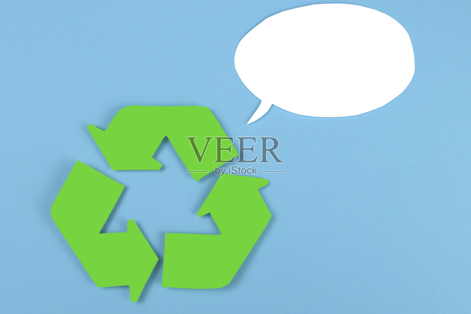 绿色的纸在蓝色的背景和演讲气球为文本回收的标志照片摄影图片