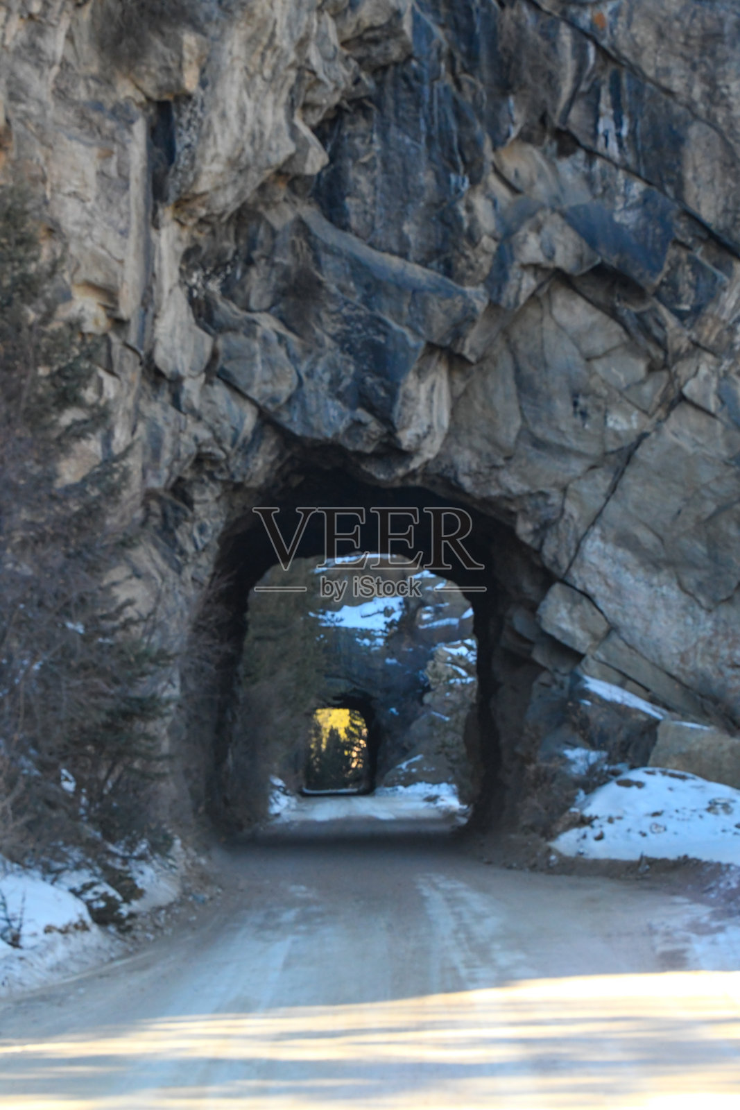 狭窄的土路和隧道穿过落基山峡谷照片摄影图片