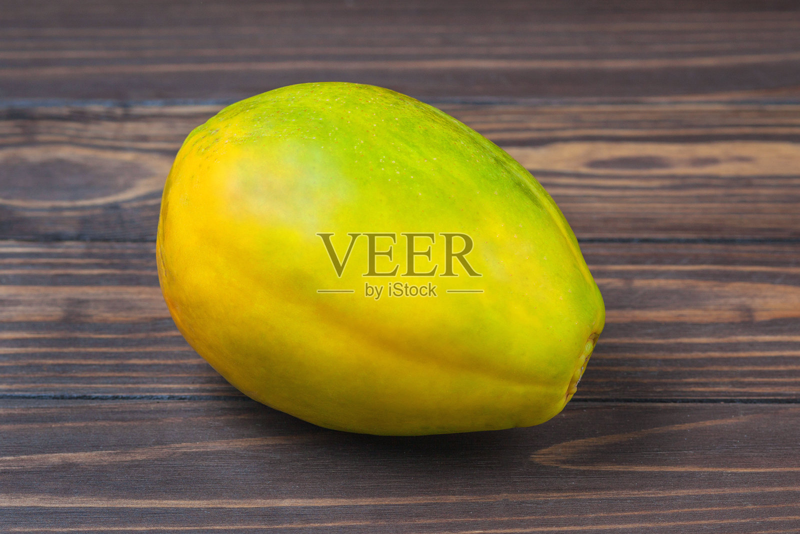 成熟的木瓜果实躺在木板的背景上照片摄影图片