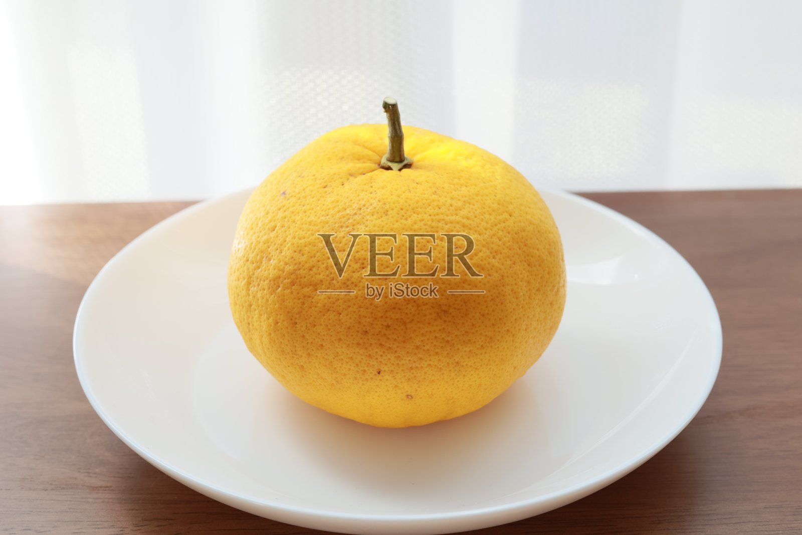 桌上放着白色盘子里的橘子照片摄影图片