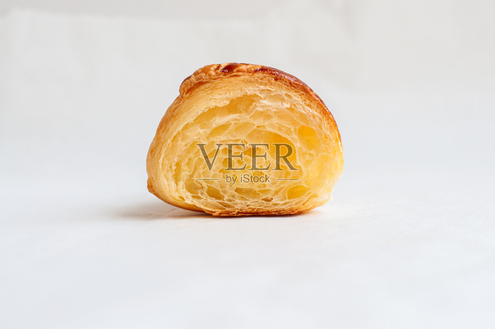 在羊皮纸上切下的牛角面包。准备吃松饼烘烤。照片摄影图片