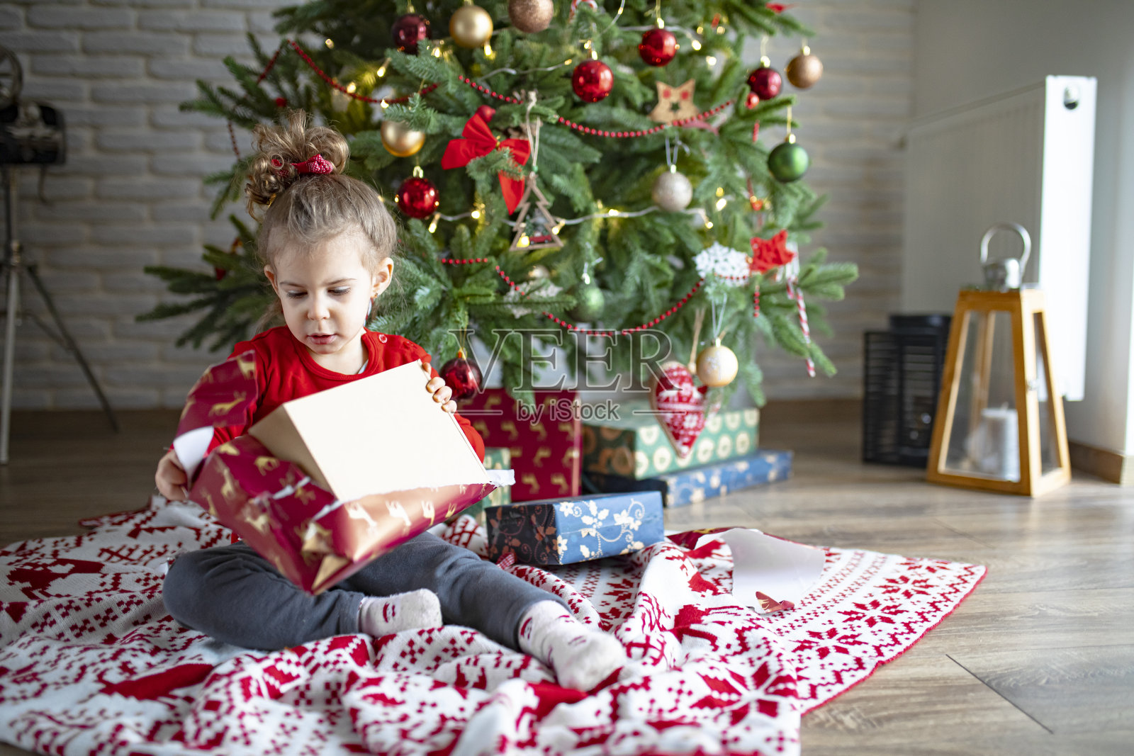 惊喜可爱的小女孩打开圣诞礼物照片摄影图片