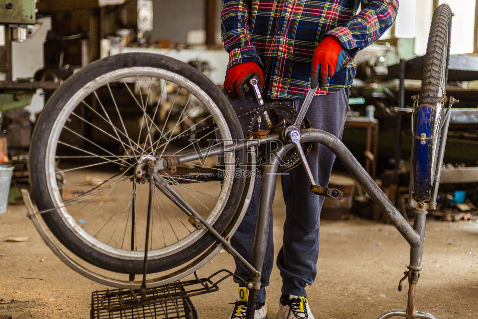 一个不知名的少年在一家自行车修理店打工，作为他的兼职工作照片摄影图片