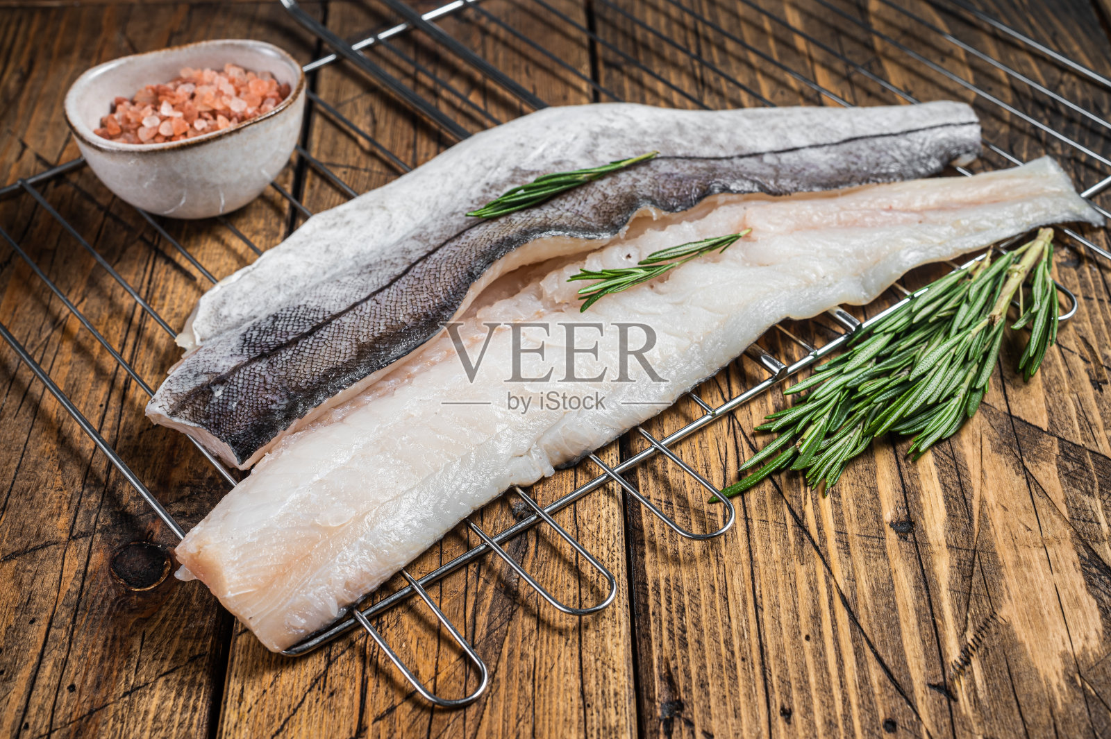 烤鱼片配迷迭香和香草。木制背景。俯视图照片摄影图片