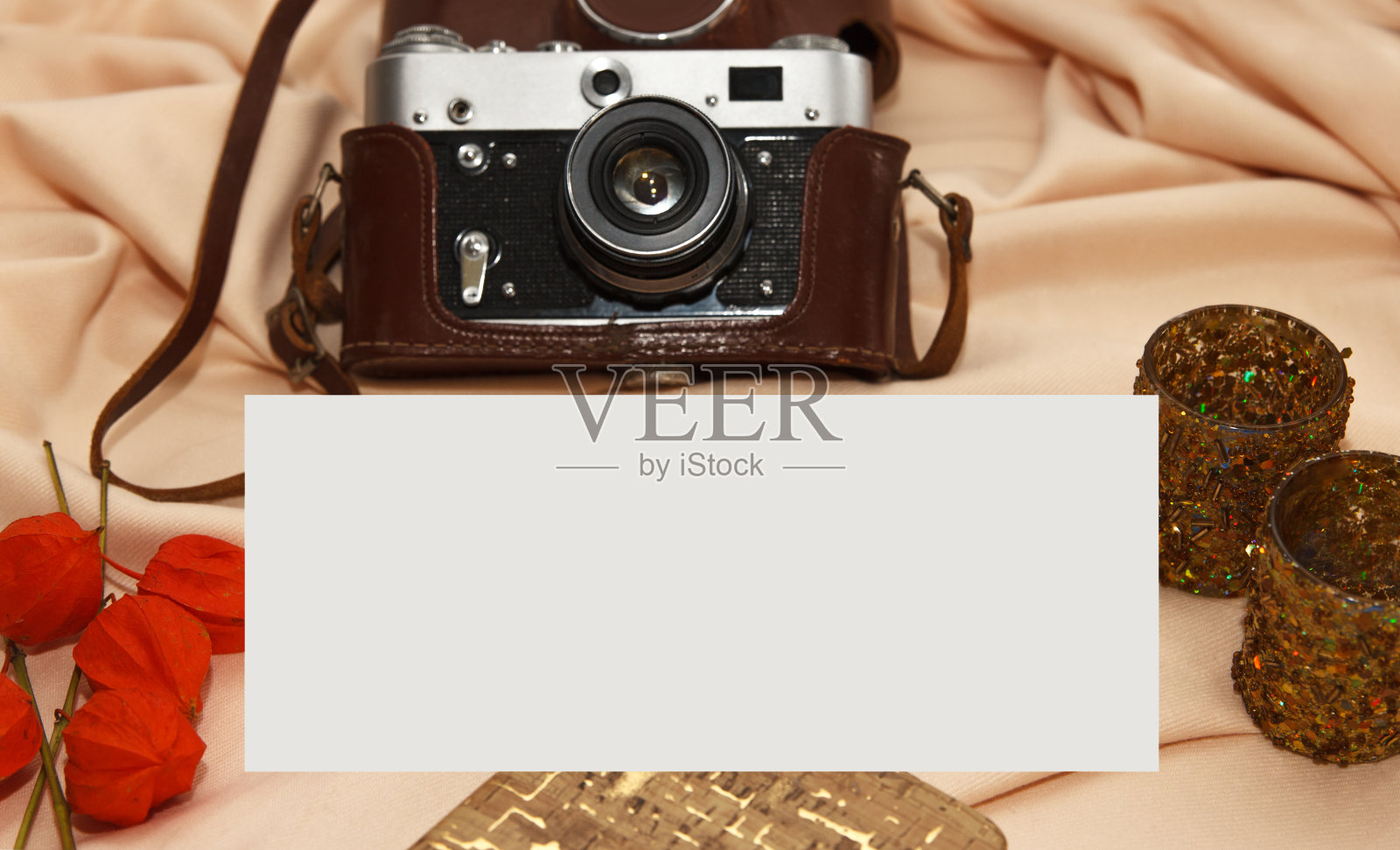 Flatlay。米色背景上放着胶卷相机、笔记本、灯台和烛台。照片摄影图片