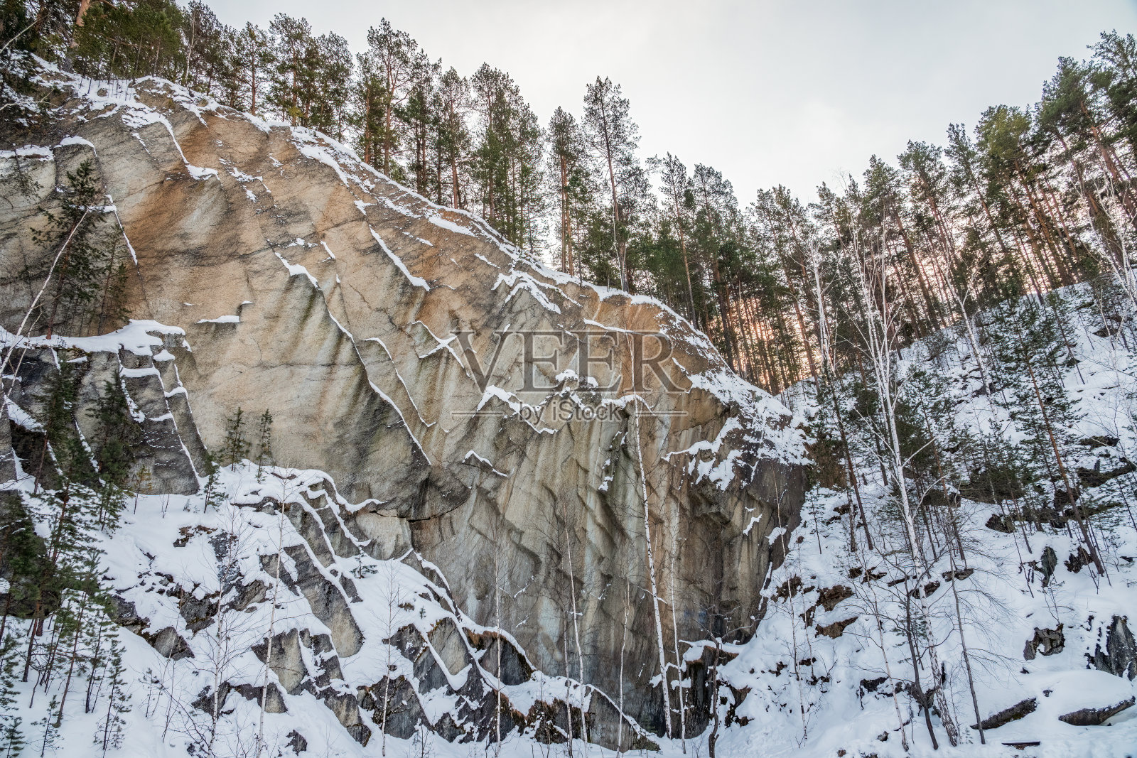 冬天，在俄罗斯叶卡捷琳堡附近的塞塞特镇，滑石采石场周围是陡峭的悬崖和岩石。照片摄影图片