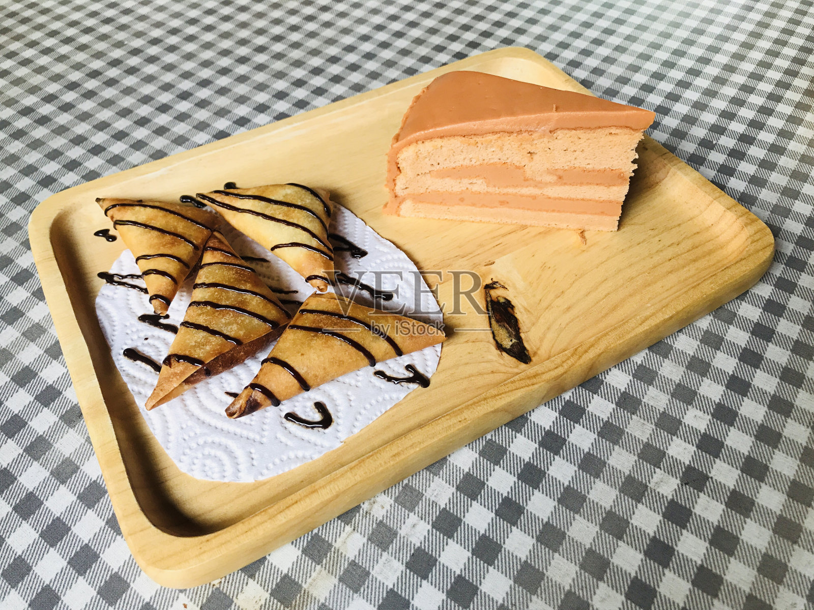 在泰国，香蕉萨莫萨和泰国茶饼放在木制托盘上。照片摄影图片