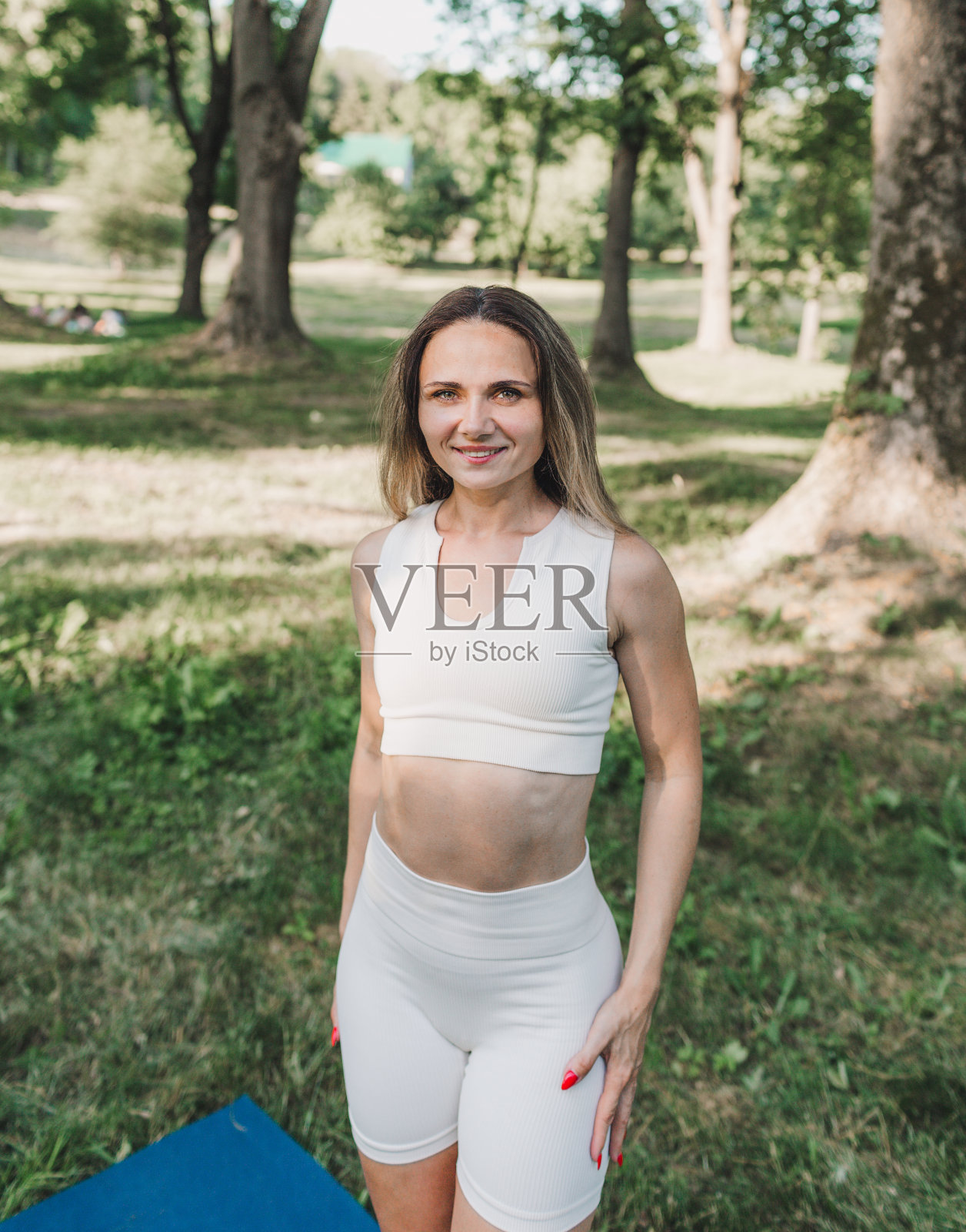 一个年轻的运动女孩在户外公园的白色衣服的肖像。照片摄影图片