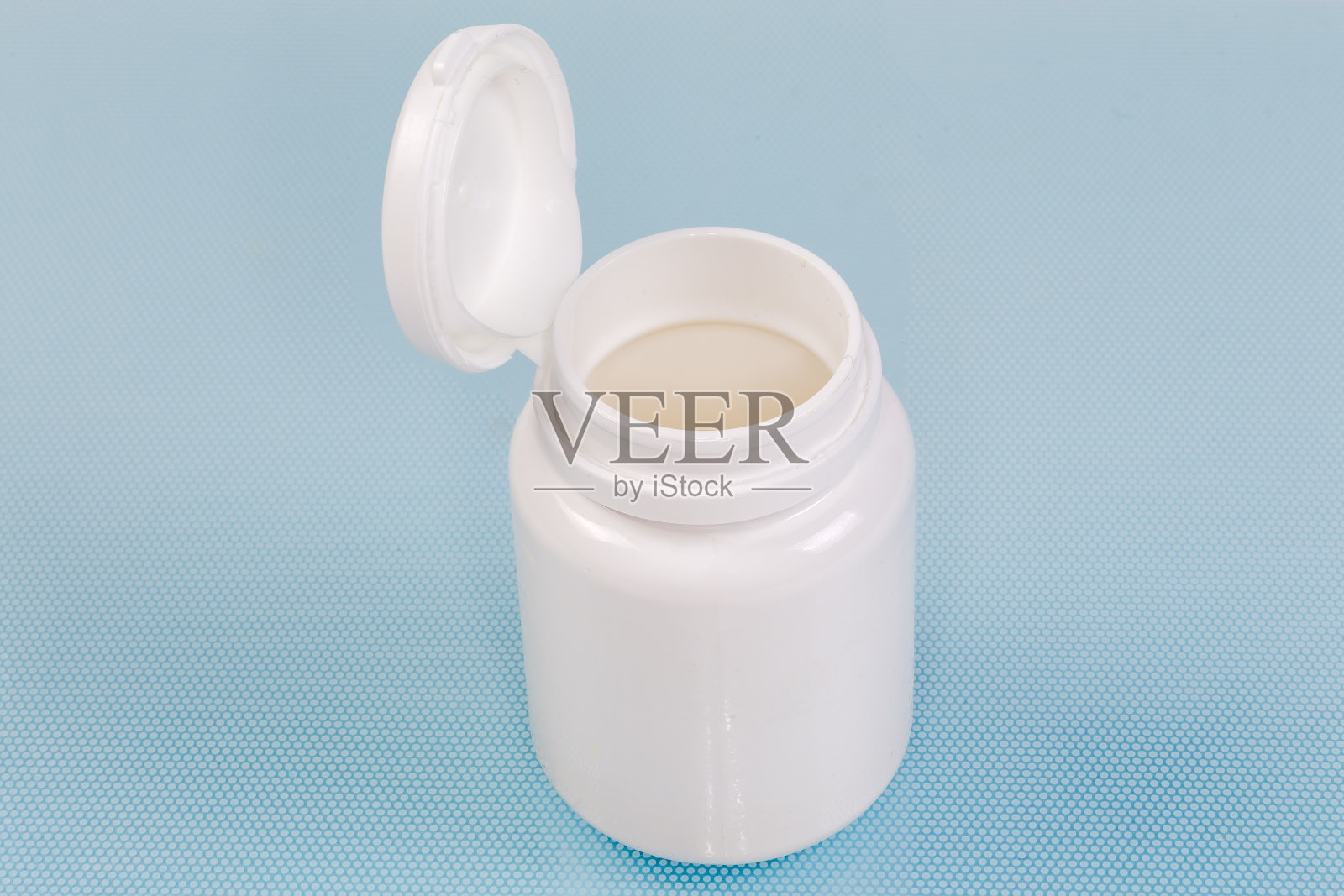 打开白色塑料瓶与药物在蓝色表面照片摄影图片