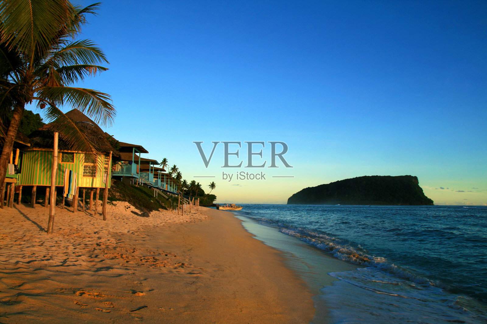 太平洋岛屿热带沙滩与传统的海滩fales度假村住宿在美丽多彩的日落天空黄昏，萨摩亚群岛照片摄影图片