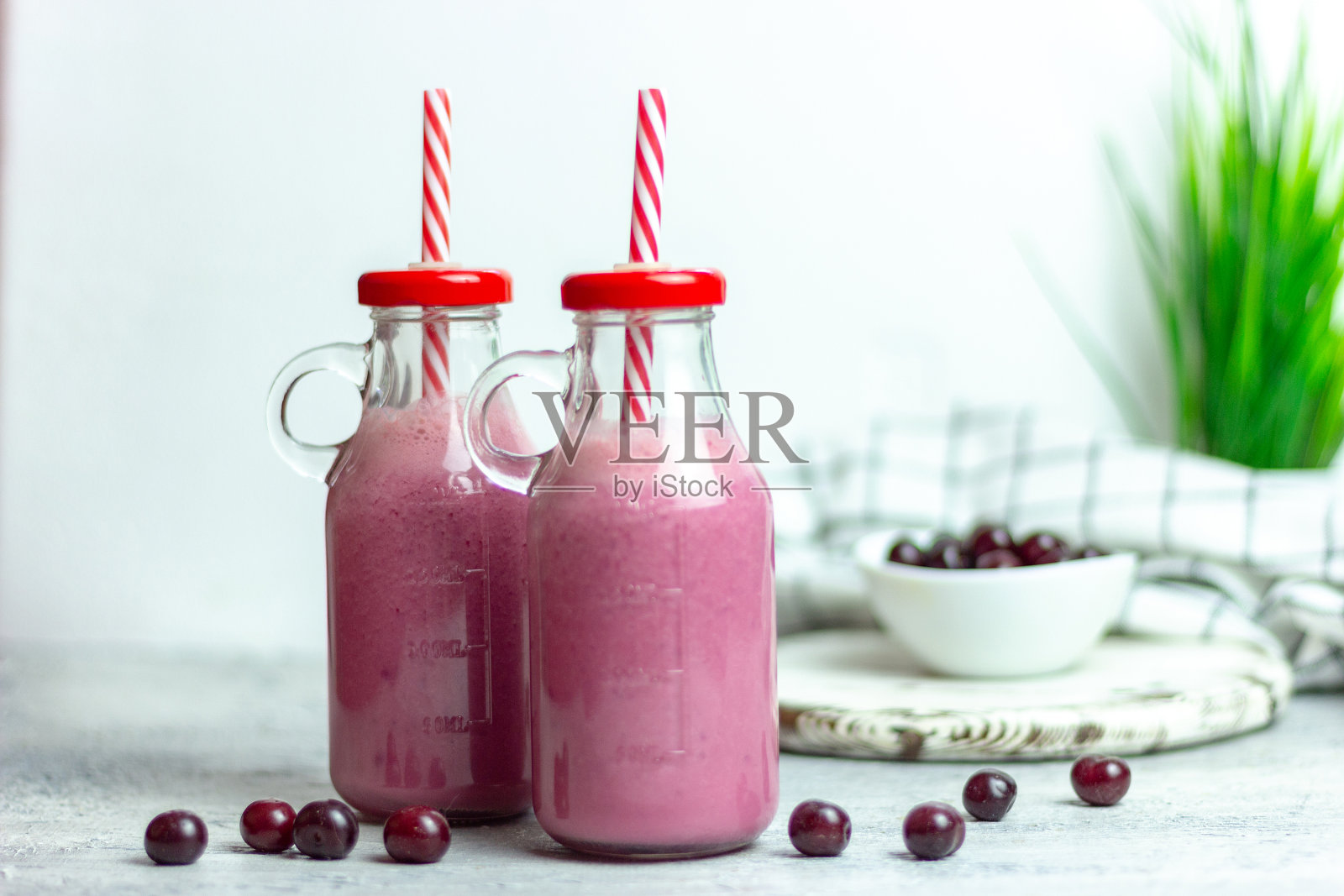 白色背景的樱桃冰沙，大块的樱桃和盘子。夏天早上早餐照片摄影图片