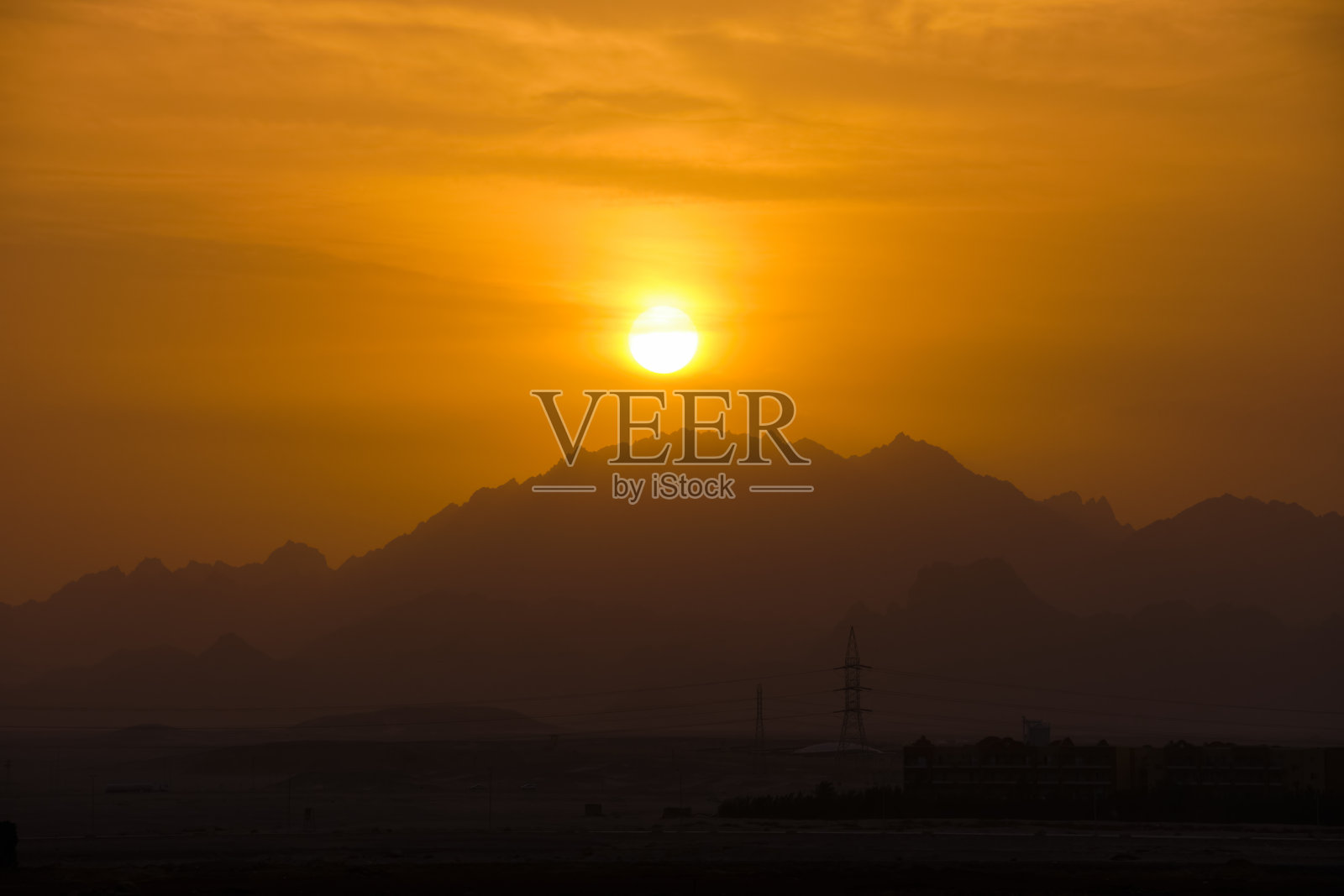 美丽的傍晚全景景观与明亮的夕阳在遥远的山峰在日落照片摄影图片