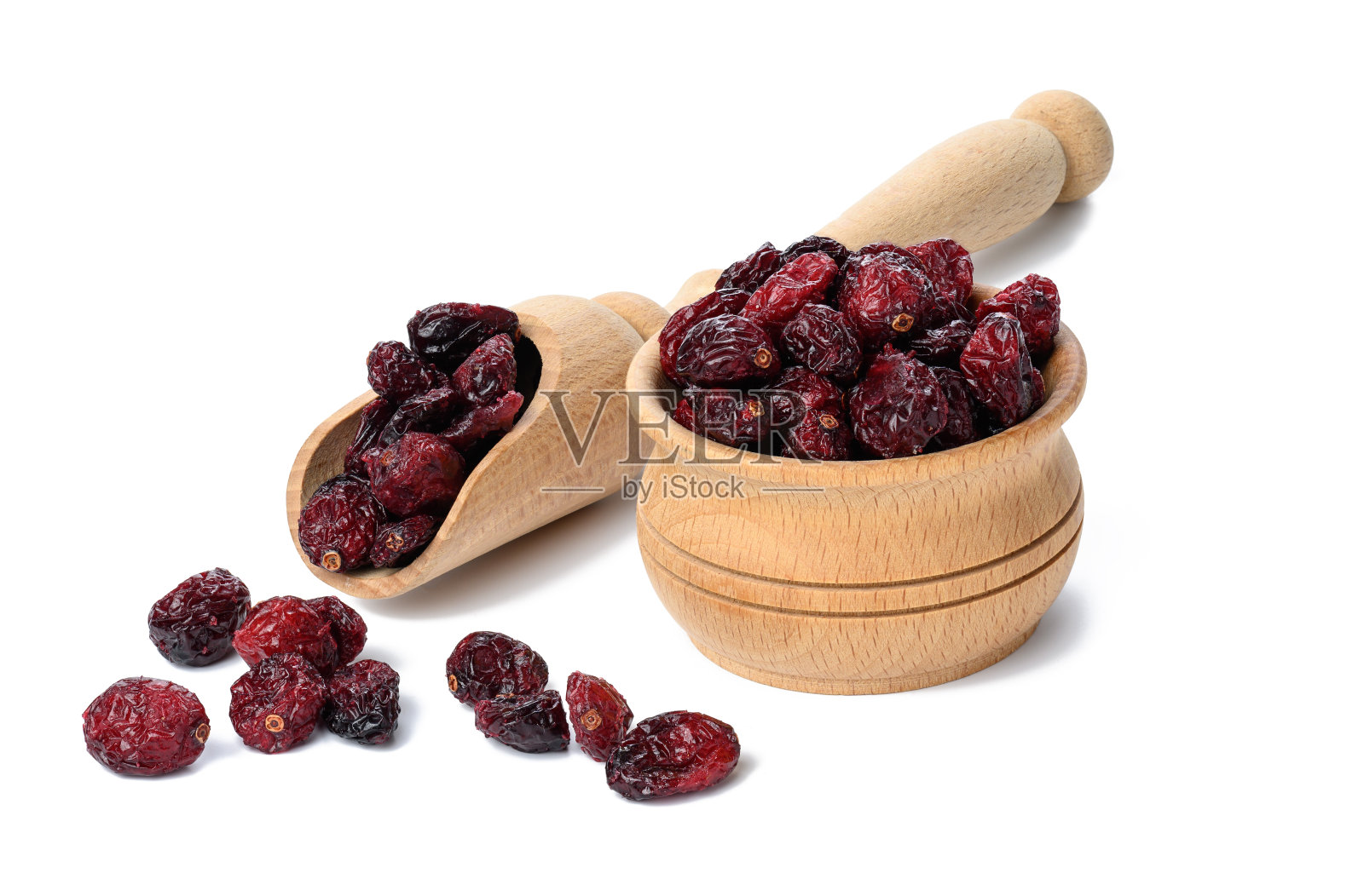 在白色背景的木碗里放一串蔓越莓干。美味的浆果照片摄影图片
