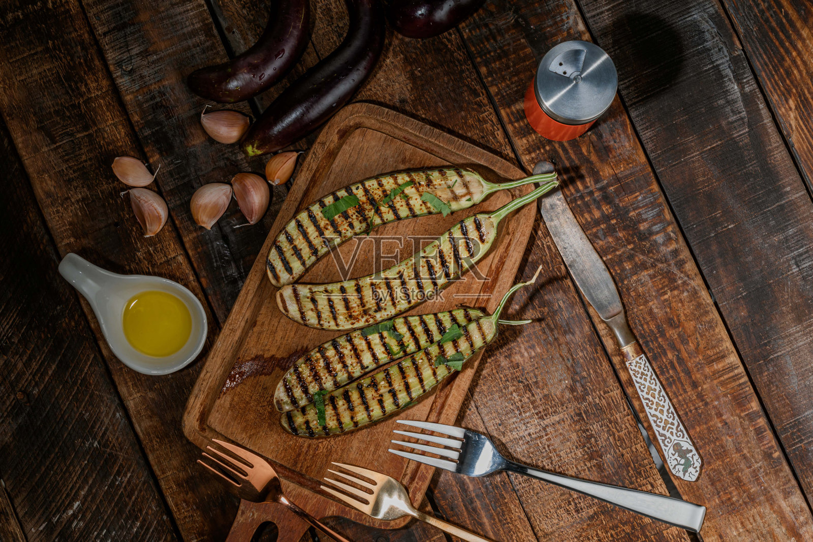 烤茄子在木背景砧板上。照片摄影图片