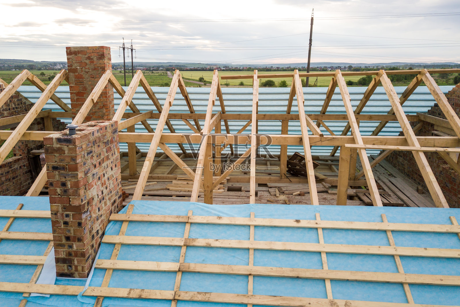 鸟瞰图，一个正在建造的带有木质屋顶框架的砖房。照片摄影图片