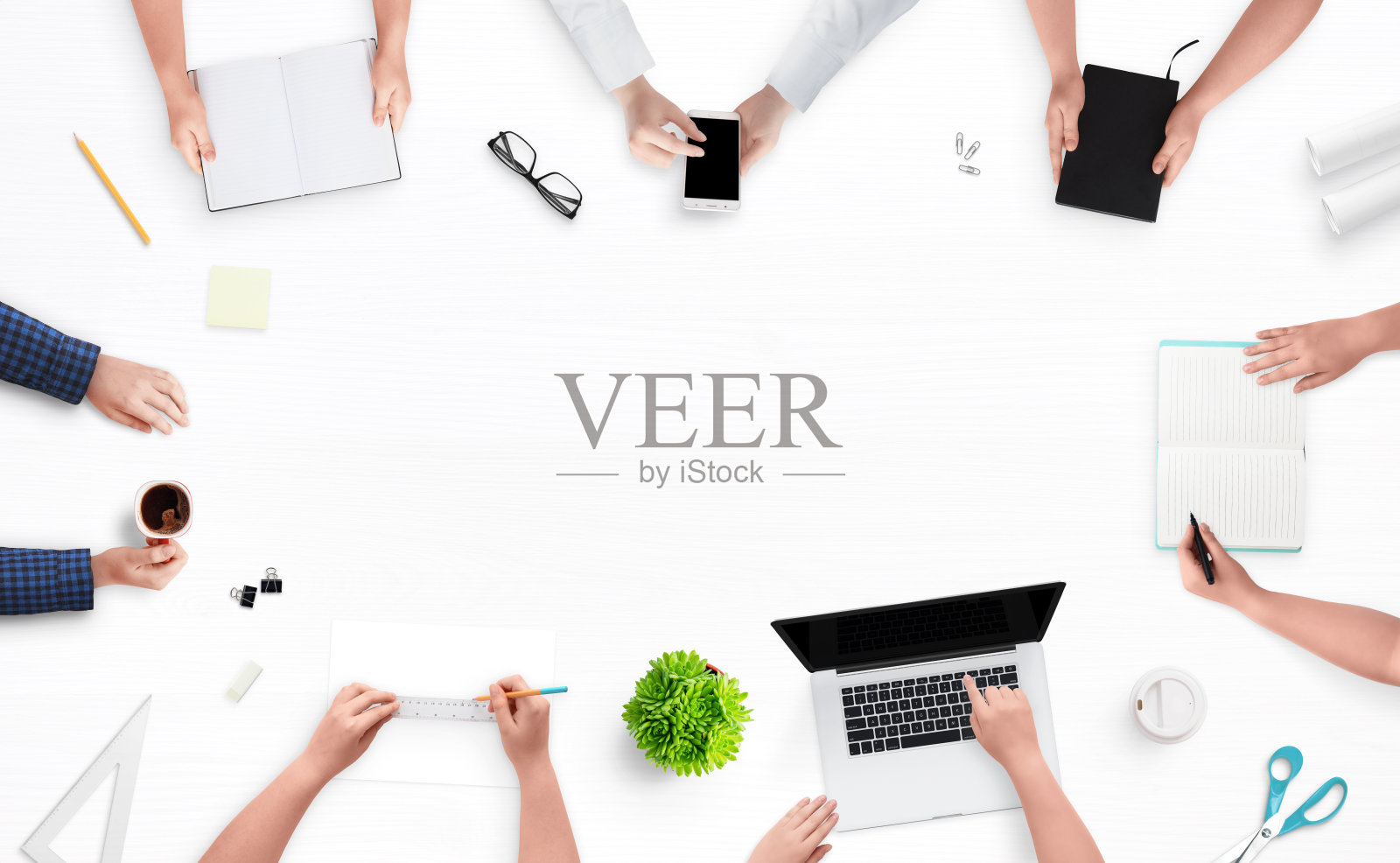 公司会议。在这张桌子上，俯视着员工的手，他们在电脑和电话前工作、做笔记、画项目、喝咖啡。中间为文本留出空白。照片摄影图片