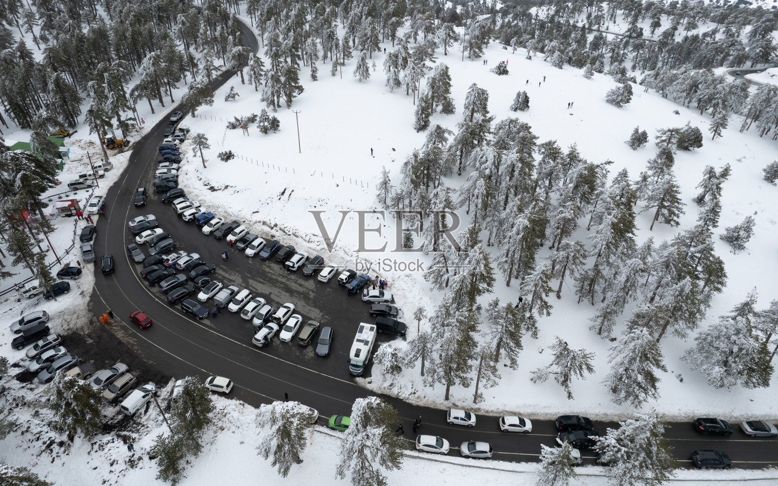 在冬天，无人机拍摄了一辆停在雪山上的汽车。冬天的季节照片摄影图片
