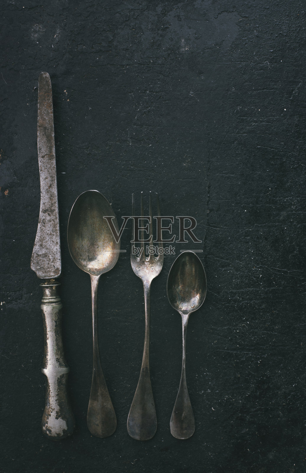 黑色质朴的桌子上的银器照片摄影图片