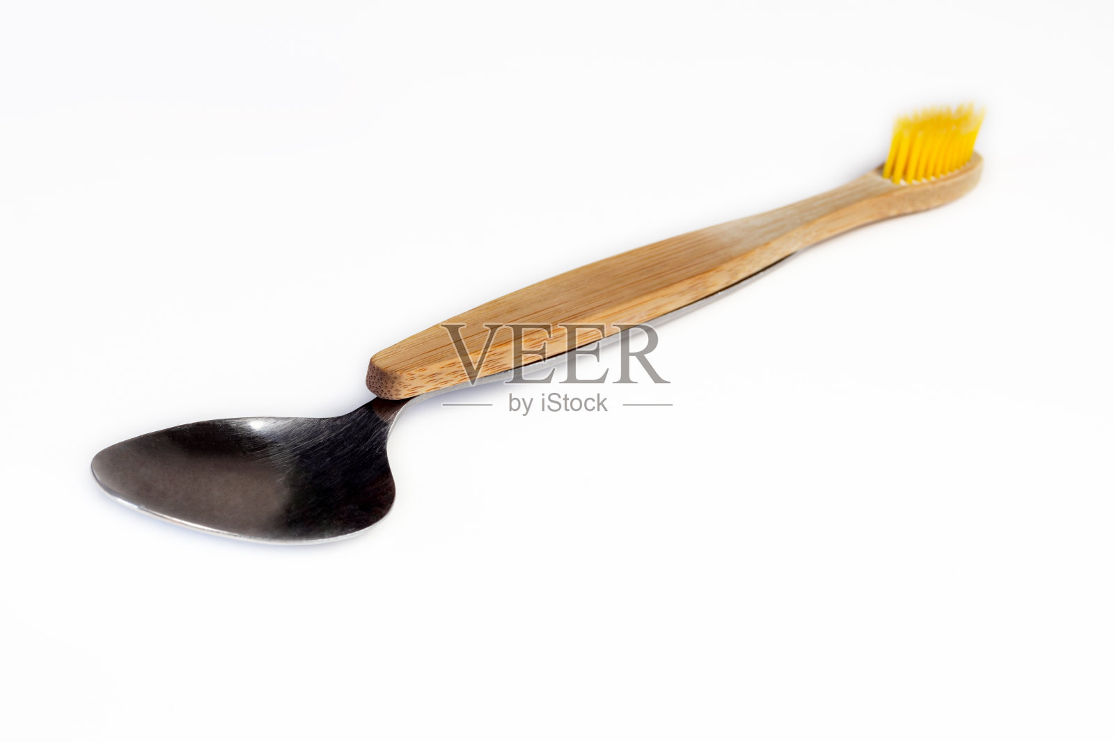 白色背景的勺子和木制牙刷。口腔卫生的概念。照片摄影图片