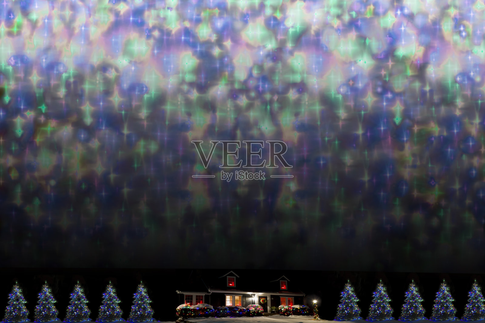 在五彩缤纷的星空下，圣诞和新年的夜晚装饰房子和树覆盖着雪照片摄影图片
