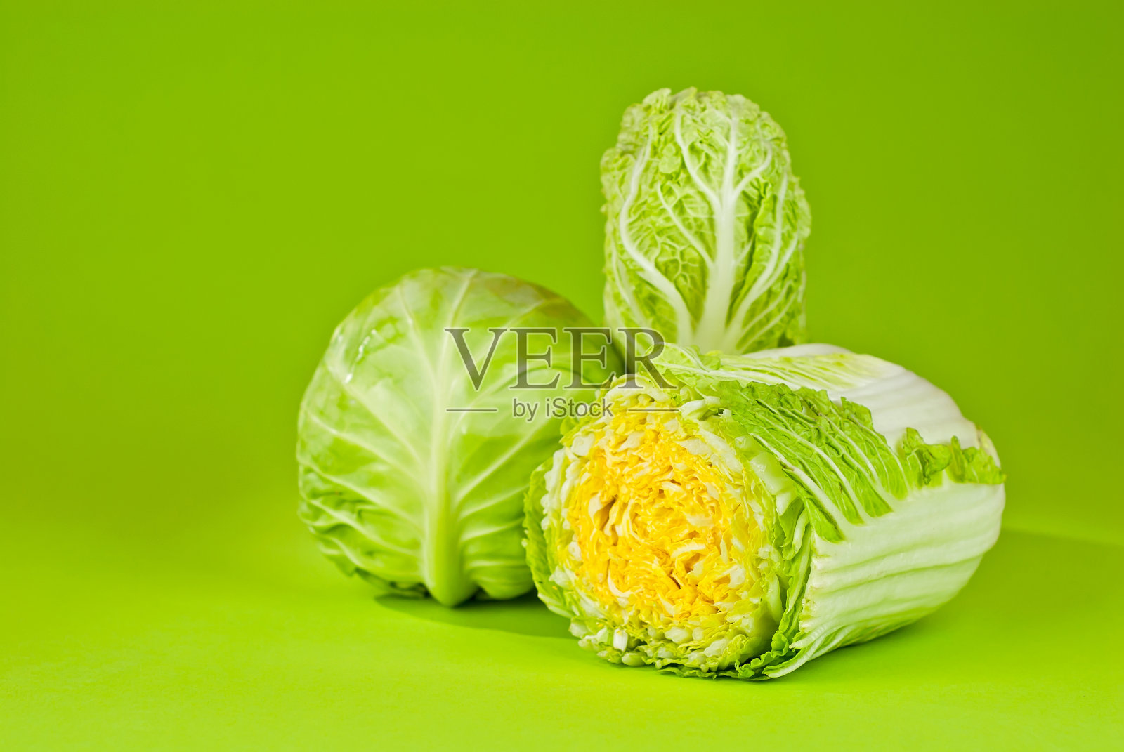 绿色背景上的大白菜。卷心菜关闭。复制空间和位置附近的绿色植物的文本。照片摄影图片