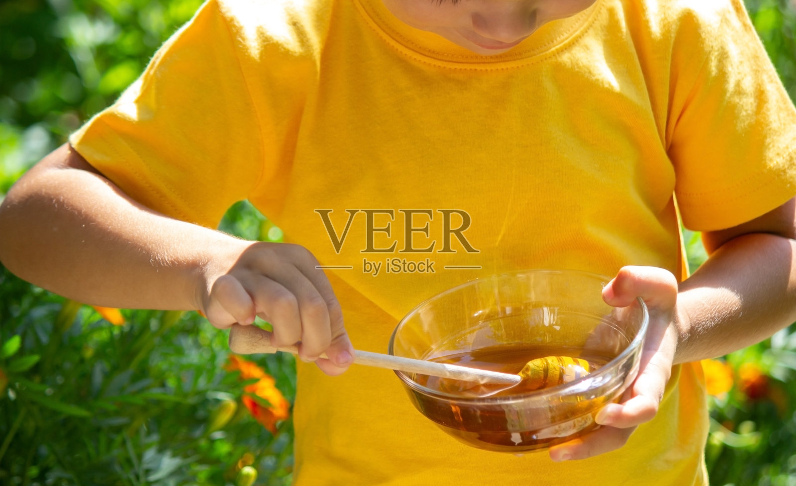 这孩子吃蜂蜜。有选择性的重点照片摄影图片