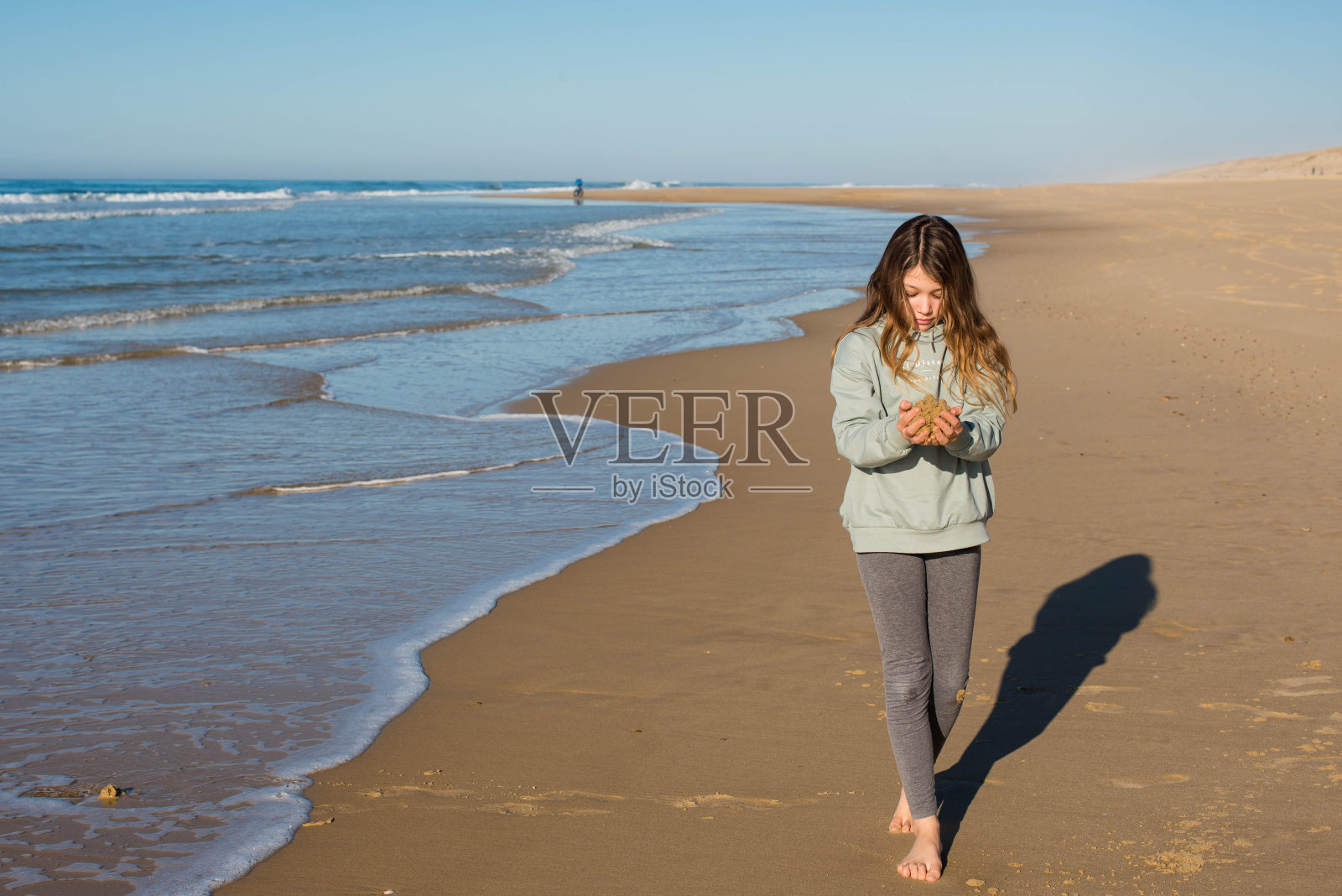 美丽的女孩赤脚走在海边的沙滩上照片摄影图片