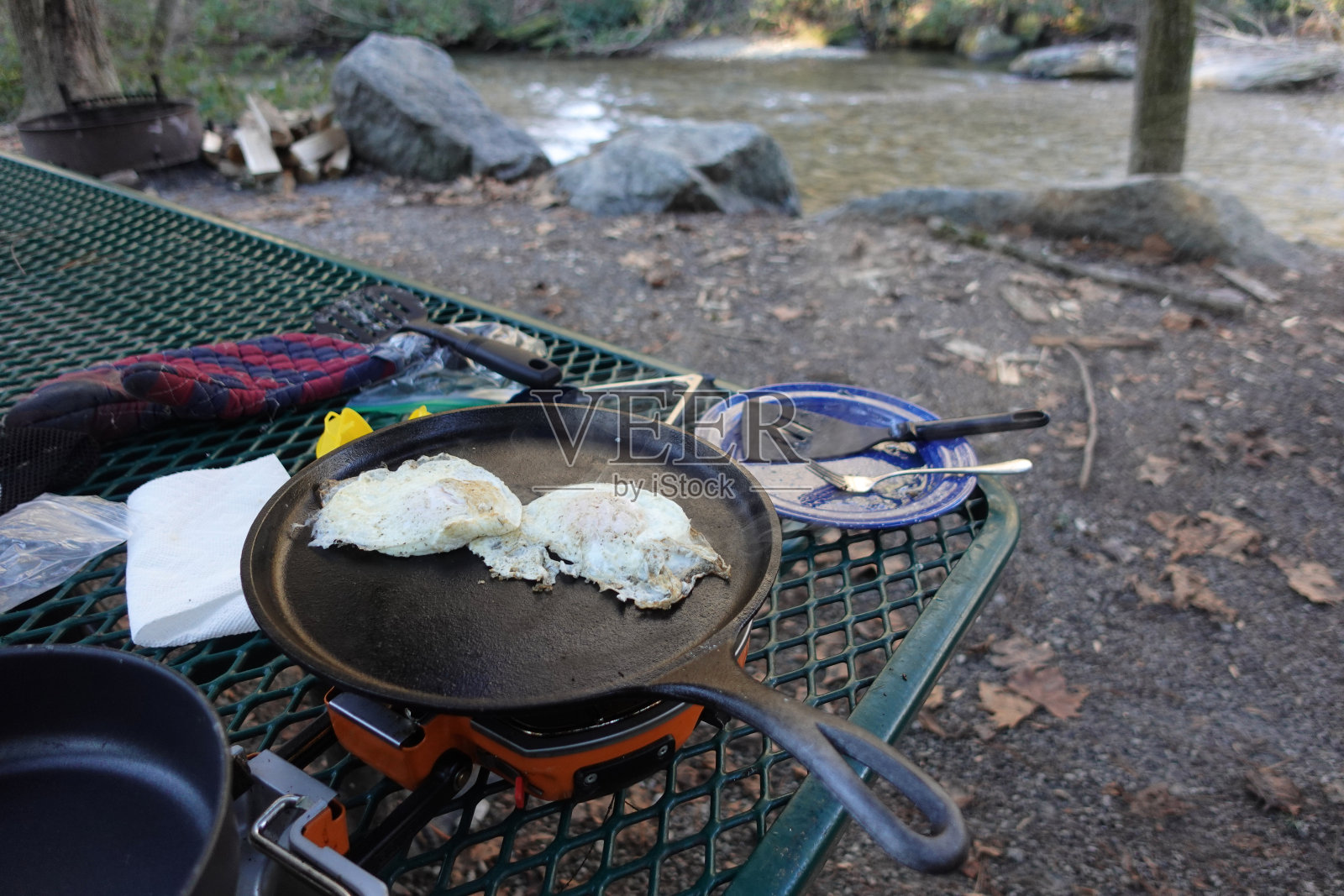 在小溪边的野营炉上煎蛋照片摄影图片