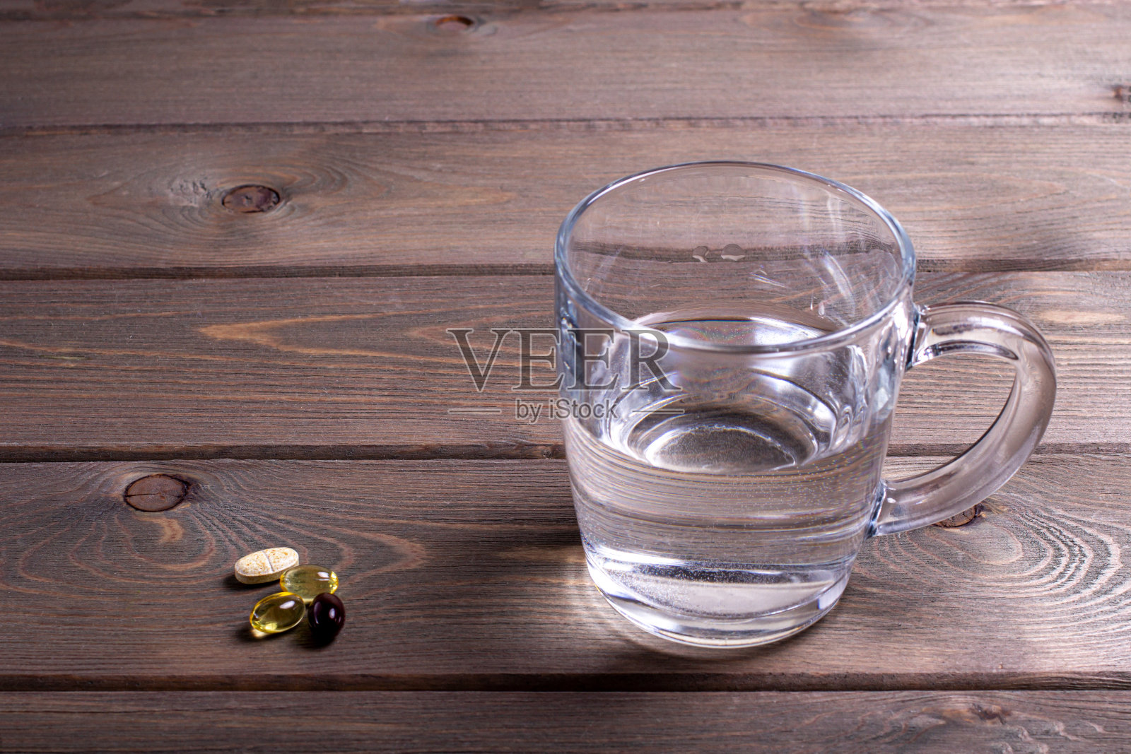 木桌上的一杯水和维生素照片摄影图片