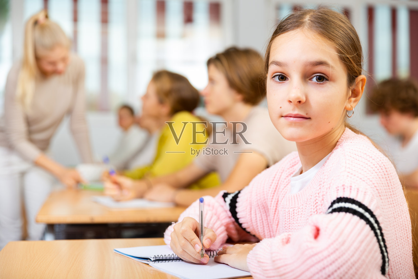 十多岁的女学生坐在教室里上课的肖像照片摄影图片