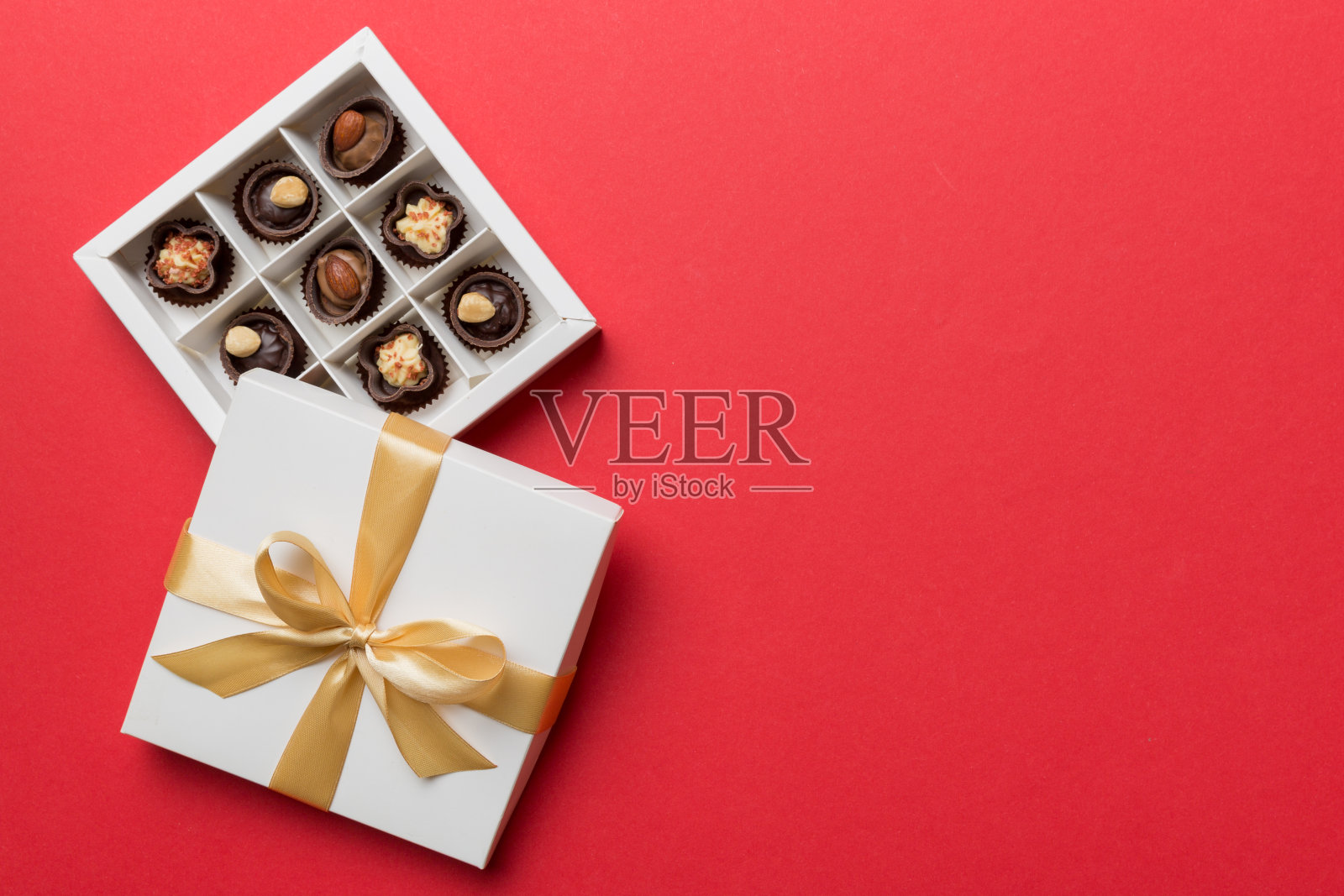 白色盒子，里面装着巧克力、糖果和金色的胶带。顶部视图与复制空间照片摄影图片