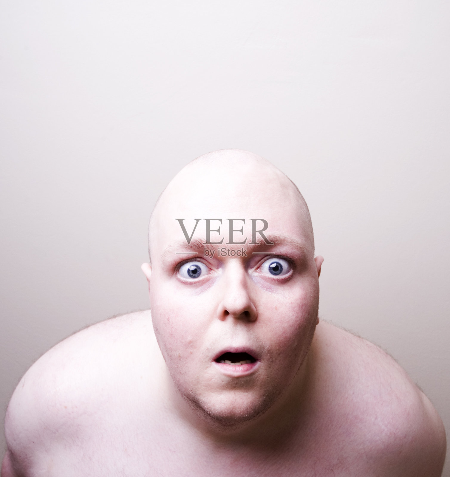 赤膊秃头男人在惊讶地盯着，在白色的背景照片摄影图片