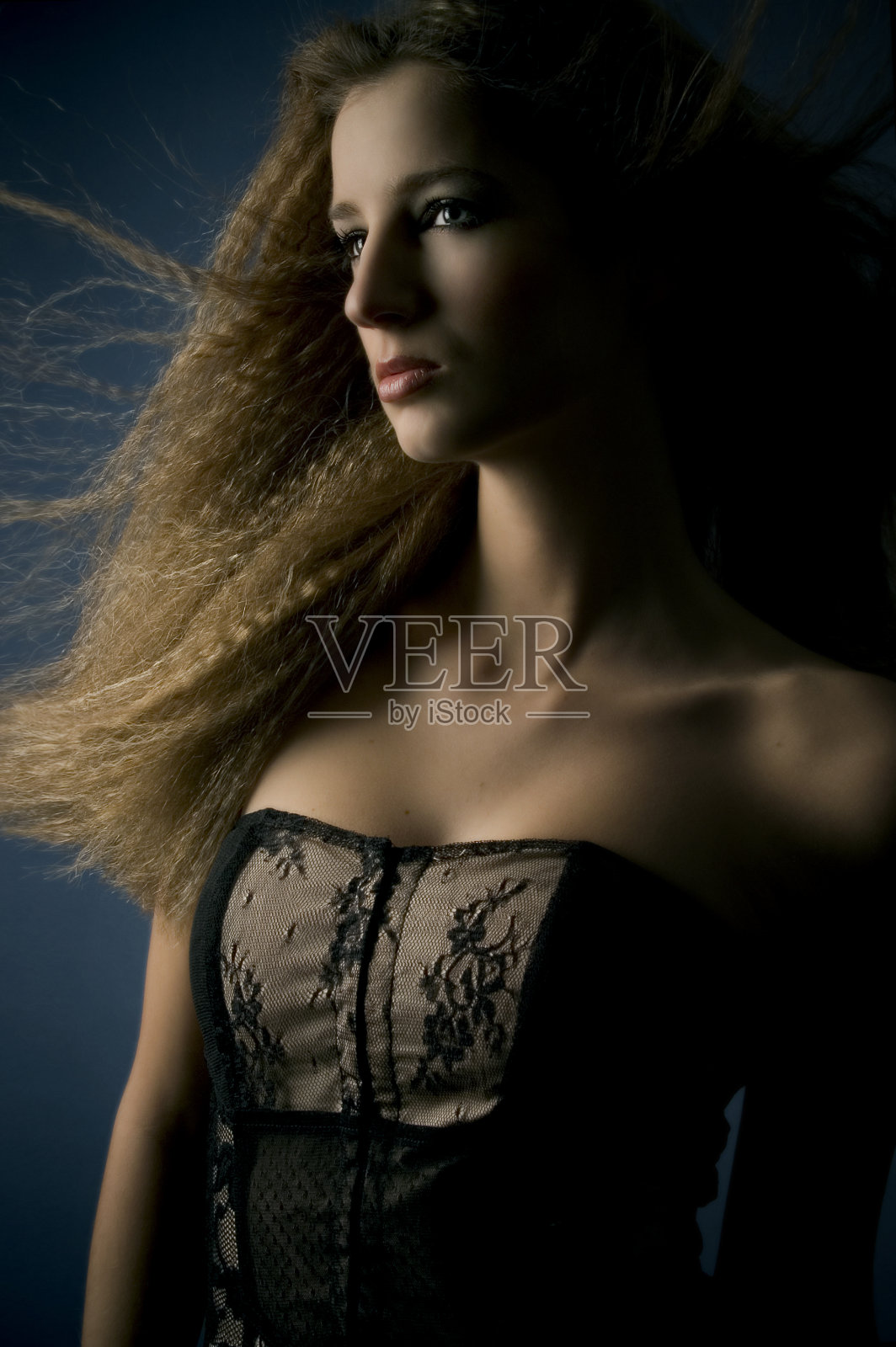 穿着紧身胸衣的年轻女子，低调照片摄影图片