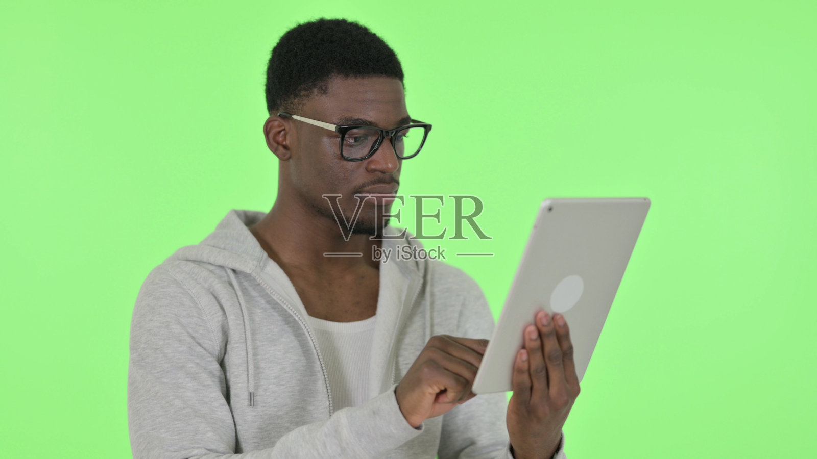 非洲人在绿色背景上使用数码平板电脑照片摄影图片