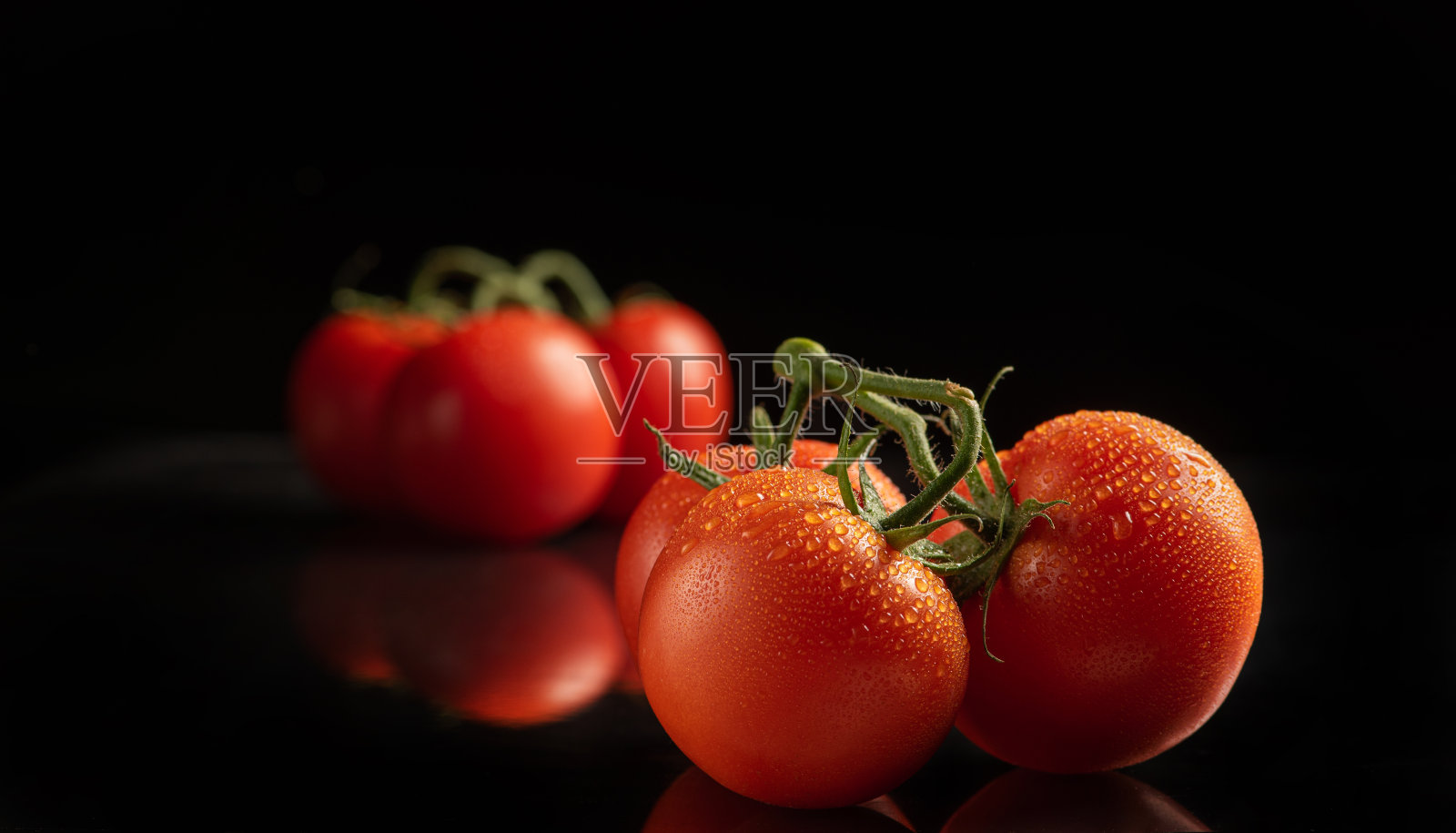 西红柿，漂亮的西红柿排列在深色的反光表面，选择性聚焦。照片摄影图片