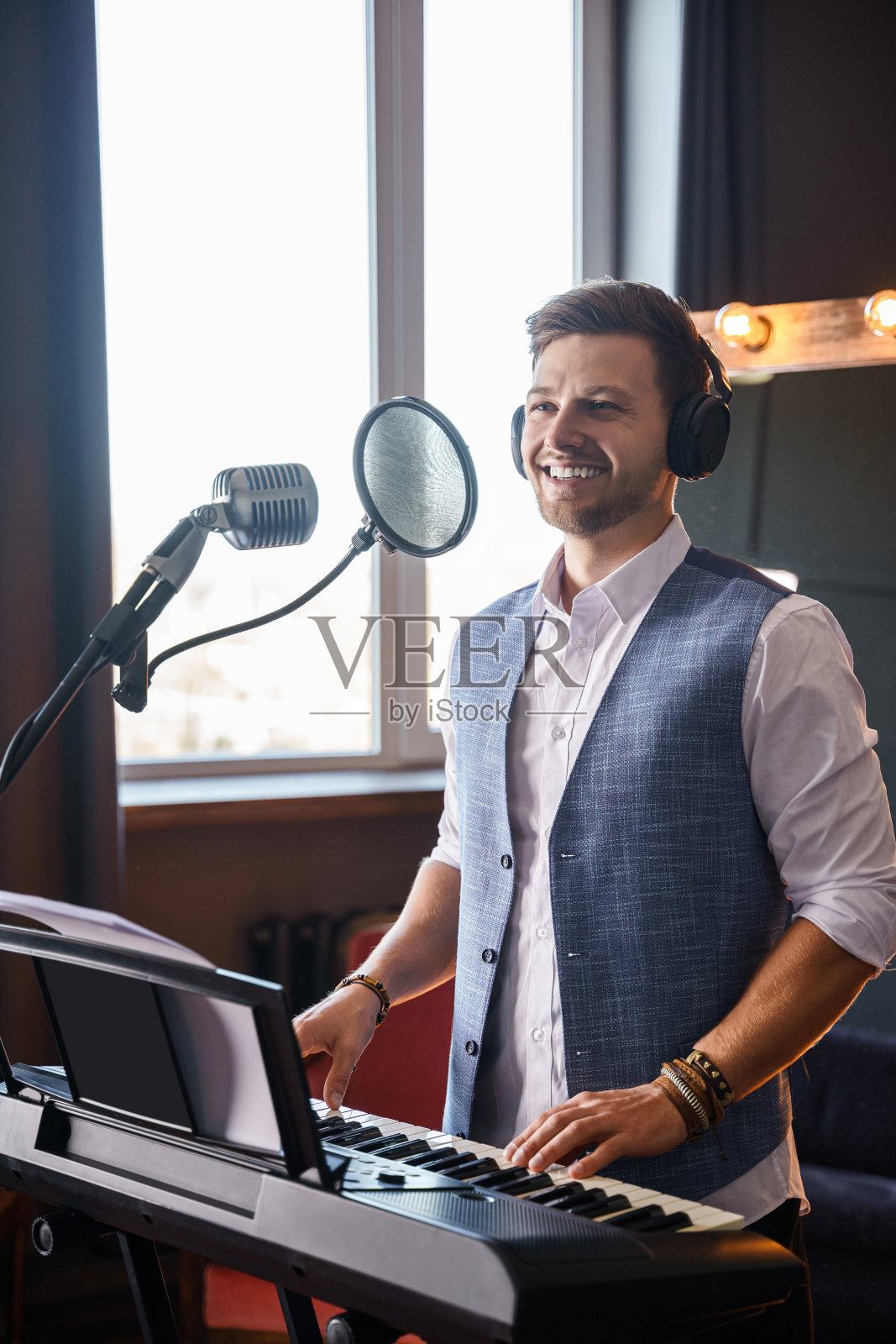 一个年轻人正在画室里弹钢琴照片摄影图片