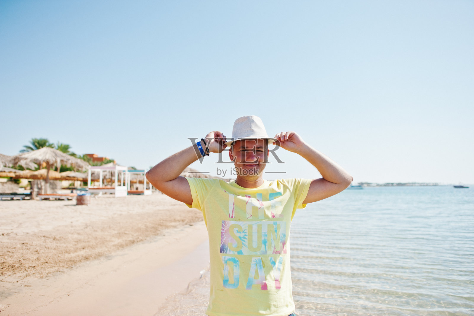 年轻男人在红海海滩戴着巴拿马帽子，埃及度假主题照片摄影图片
