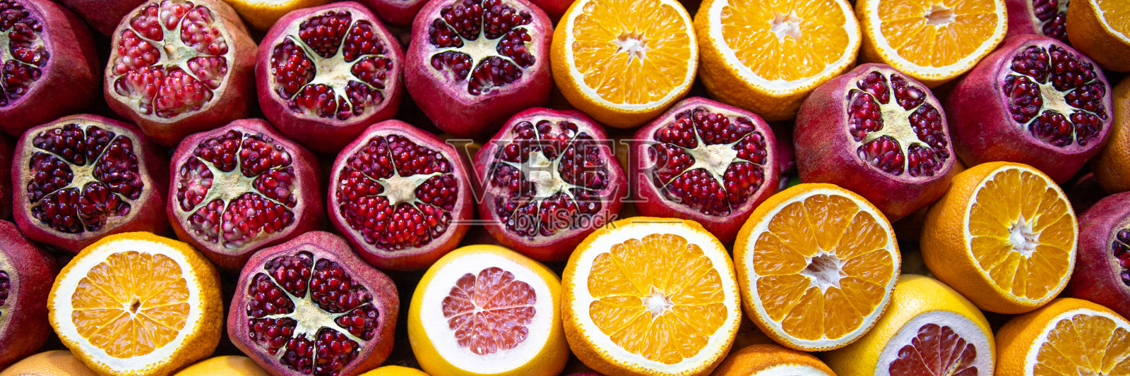 柜台上有石榴、橙子和葡萄柚照片摄影图片