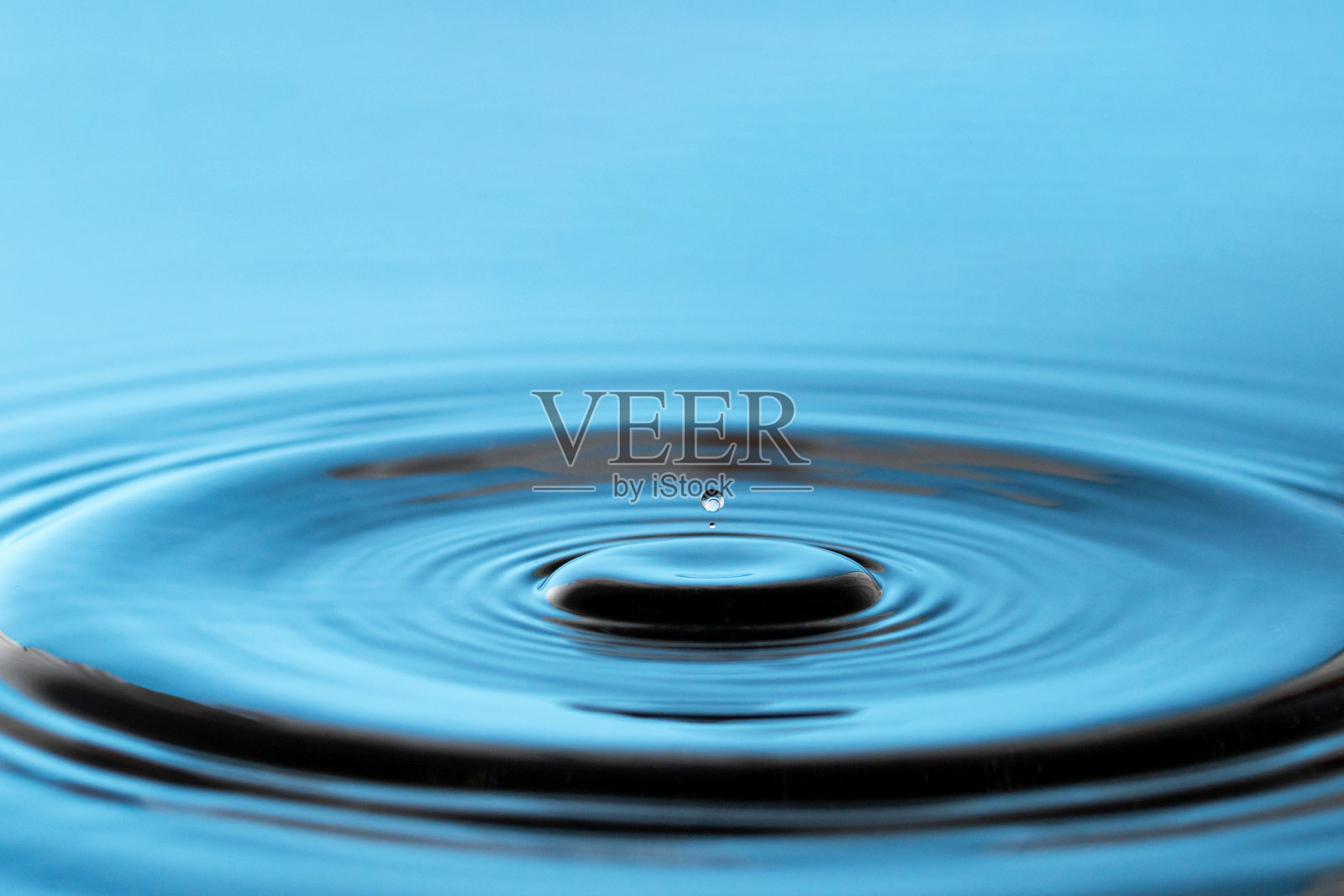 蓝色的水在水面上溅起了水花和水珠照片摄影图片