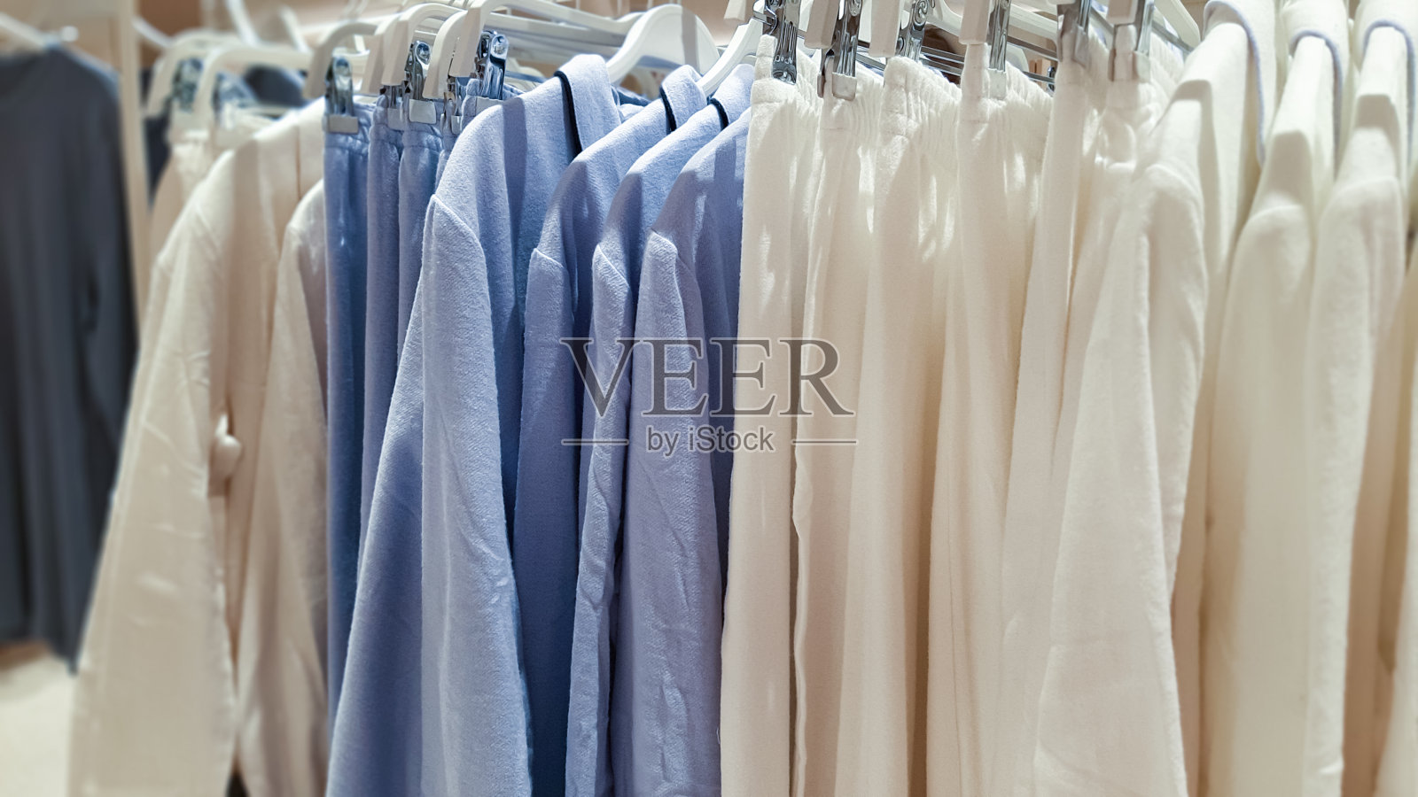 在一家时装店的陈列室里，衣架上挂着一件蓝白相间的睡衣照片摄影图片