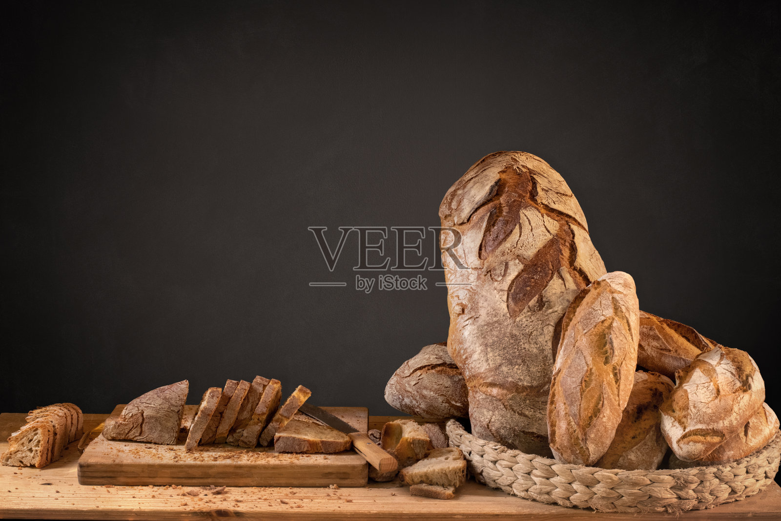 一篮子的手工面包和切片，在黑板上留有复制空间照片摄影图片