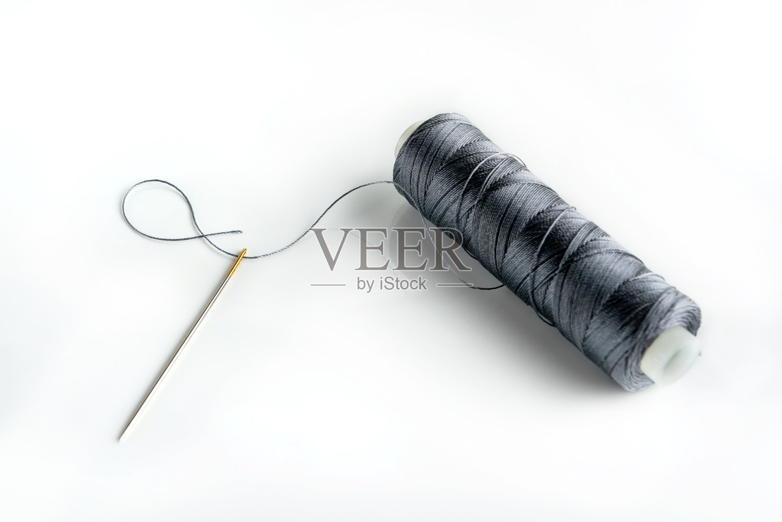 针和线轴在白色背景上闭合与复制空间。穿过针眼。照片摄影图片